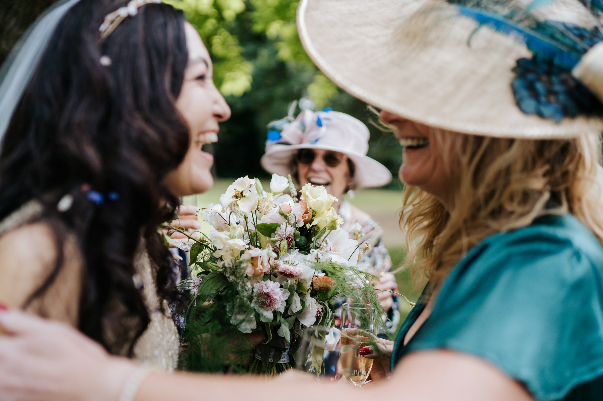 Close-up photograph of three women smiling at Orleans House Gallery after wedding ceremony