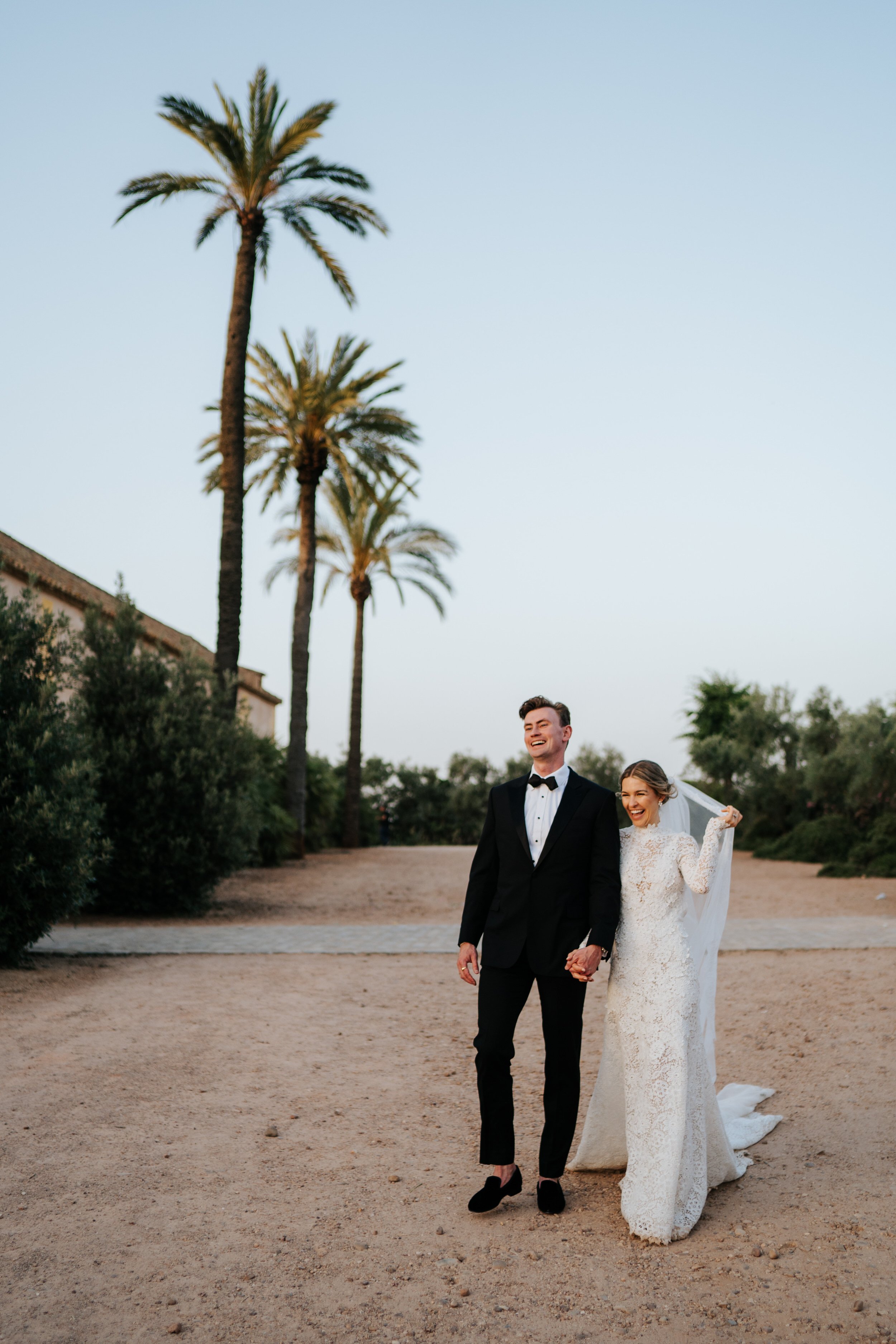 Bride and groom walk towards camera in couple's portrait during Seville wedding
