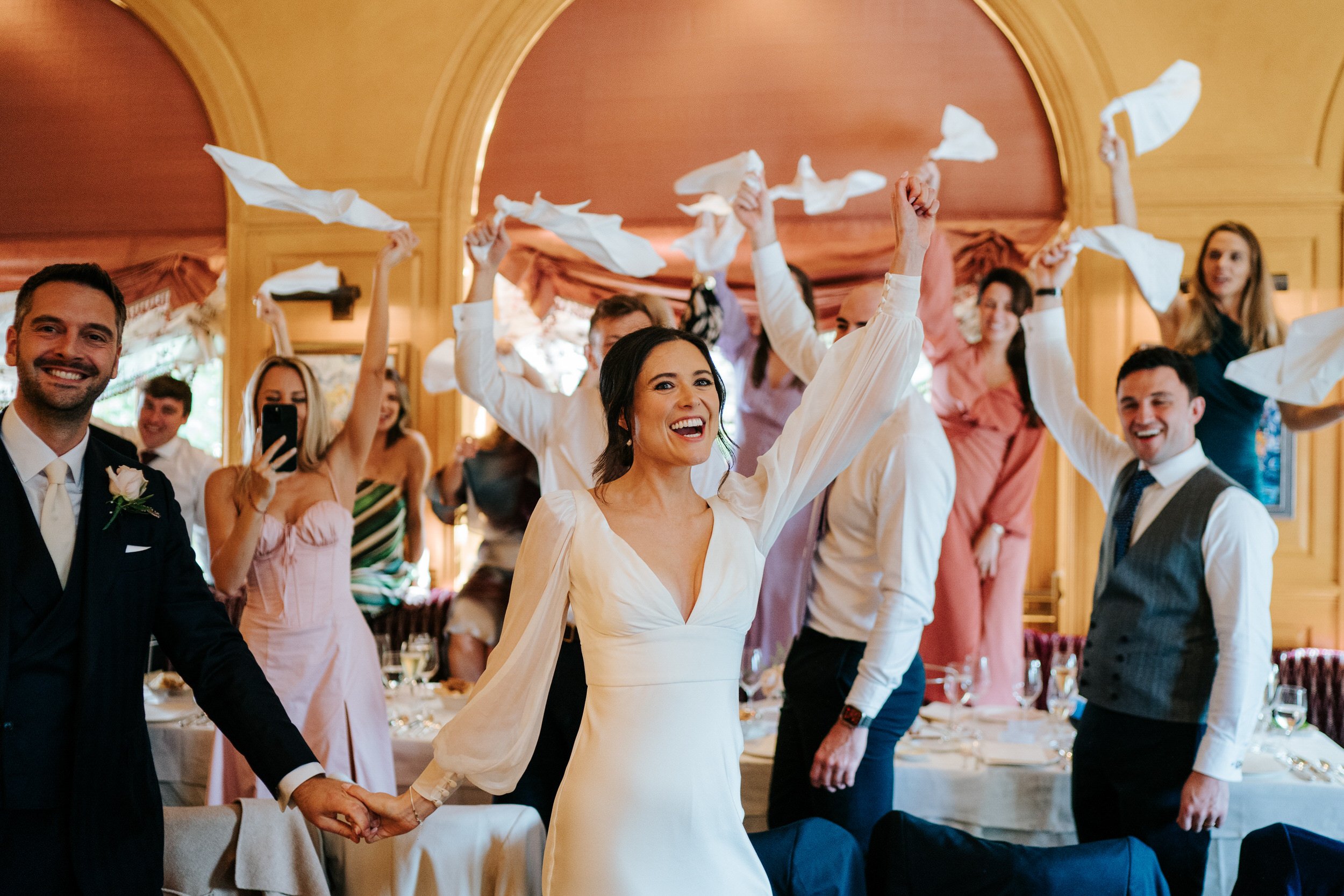 Bride and groom make entrance into Scott's dining room as guests wave their napkins in the air