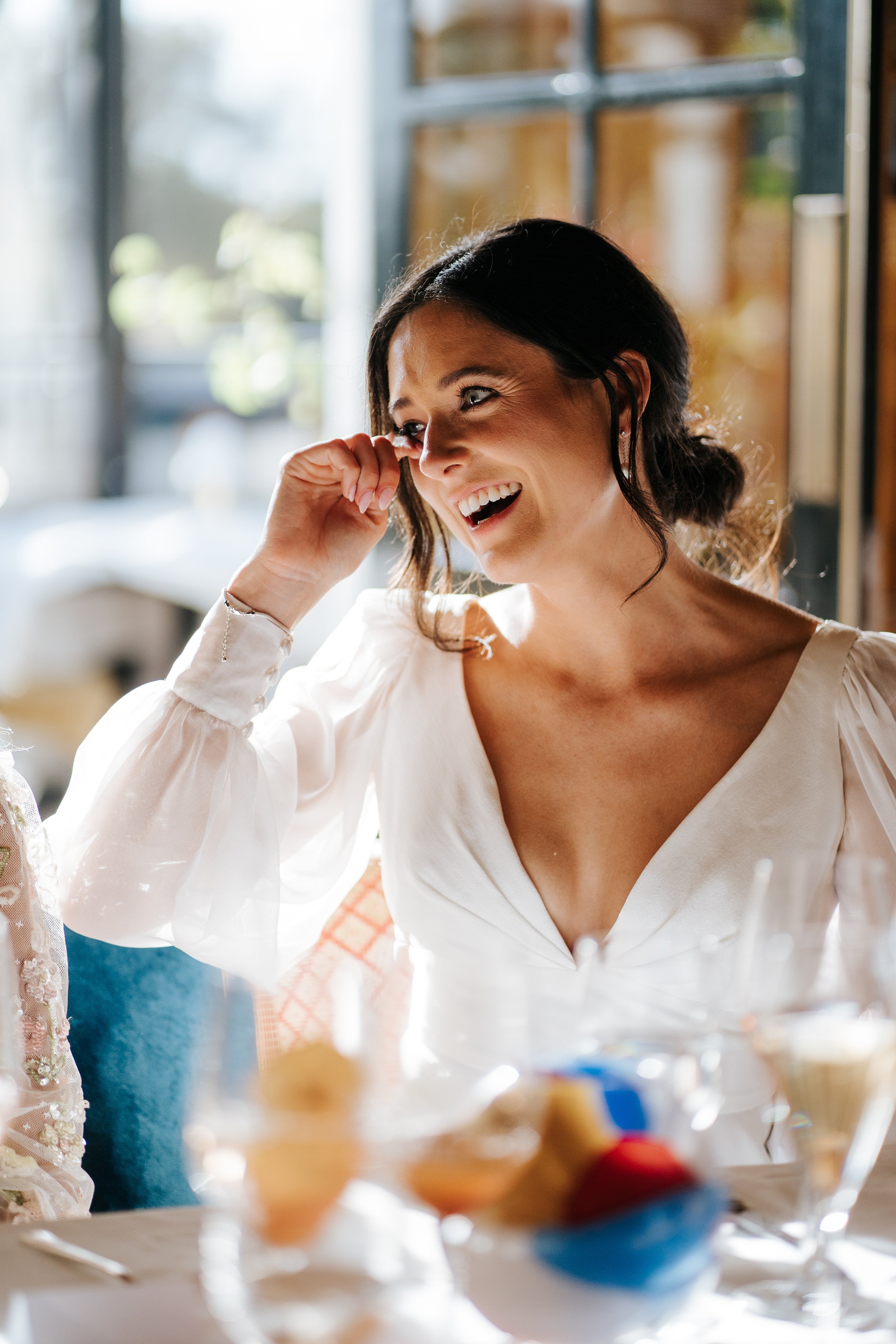 Close-up photograph of bride wiping a tear off her face during wedding speeches at Scott's Richmond