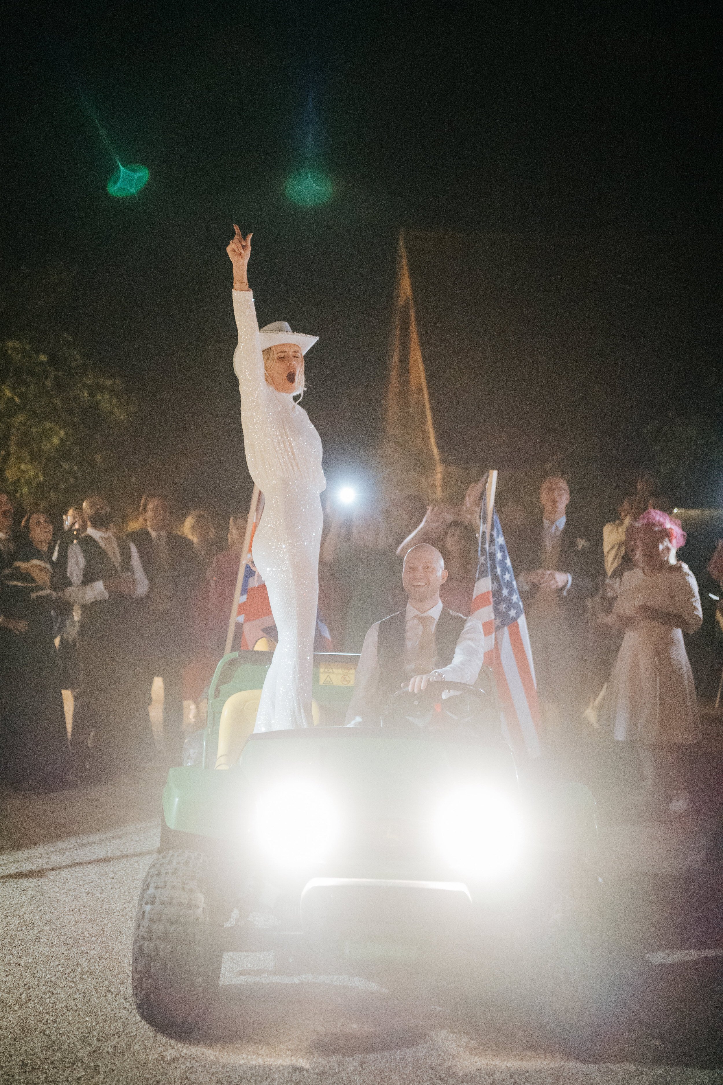 Bride and groom make epic wedding exit as bride stands on buggy and punches air in excitement