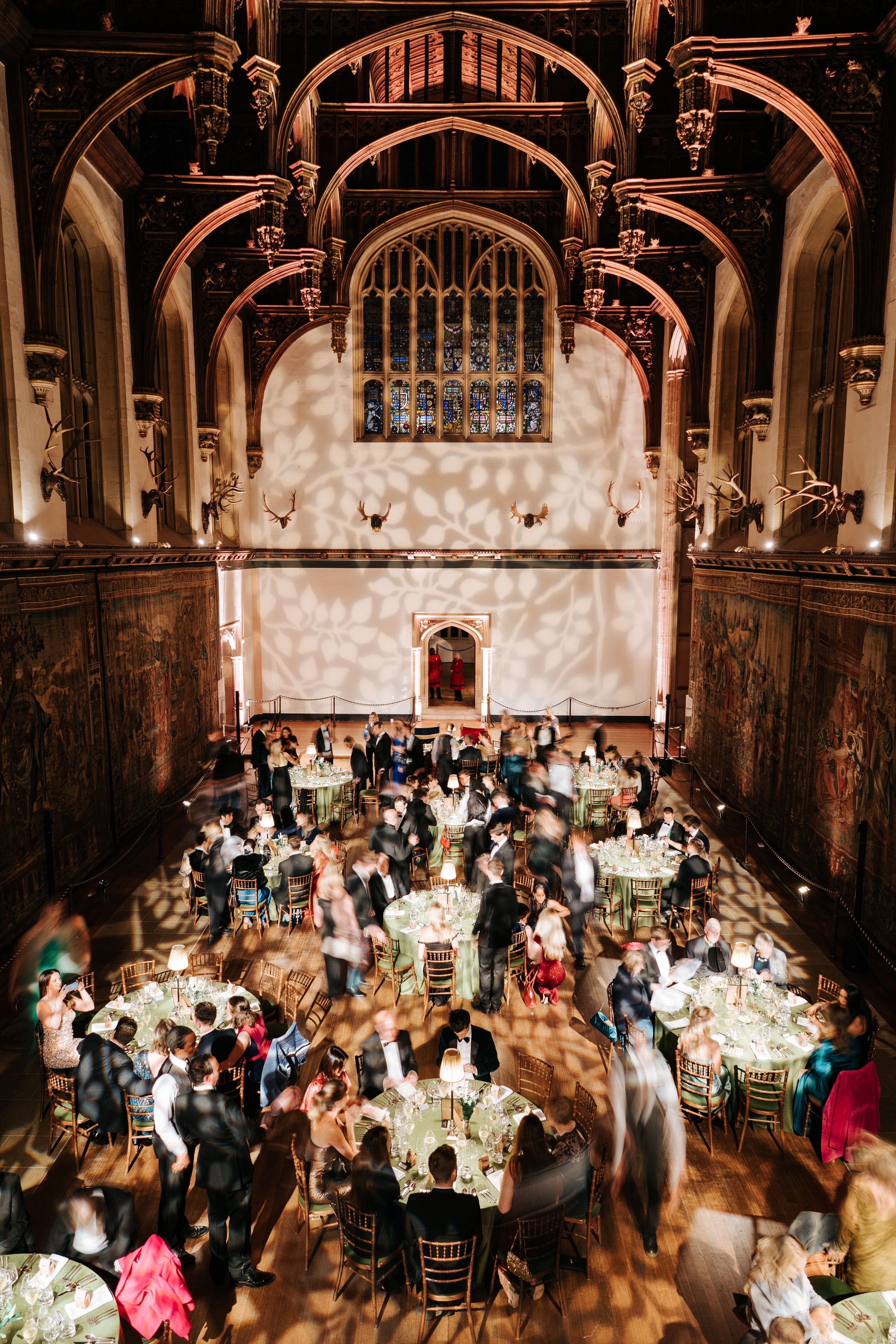 Aerial, long-exposure photograph of Hampton Court Palace's Great Hall during beautifully decorated wedding reception