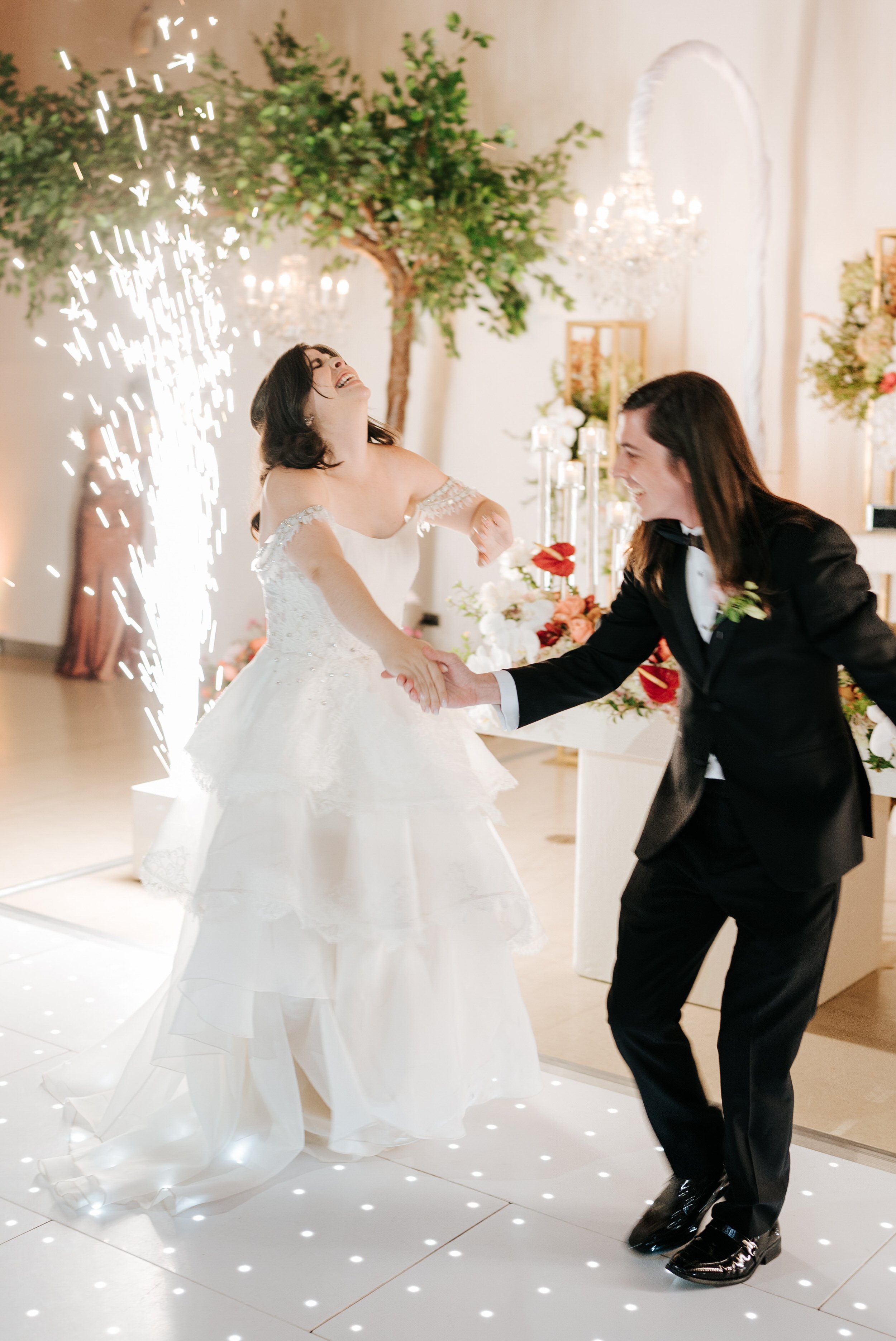 Bride and groom have exciting first dance as sparkler cannons go off behind them
