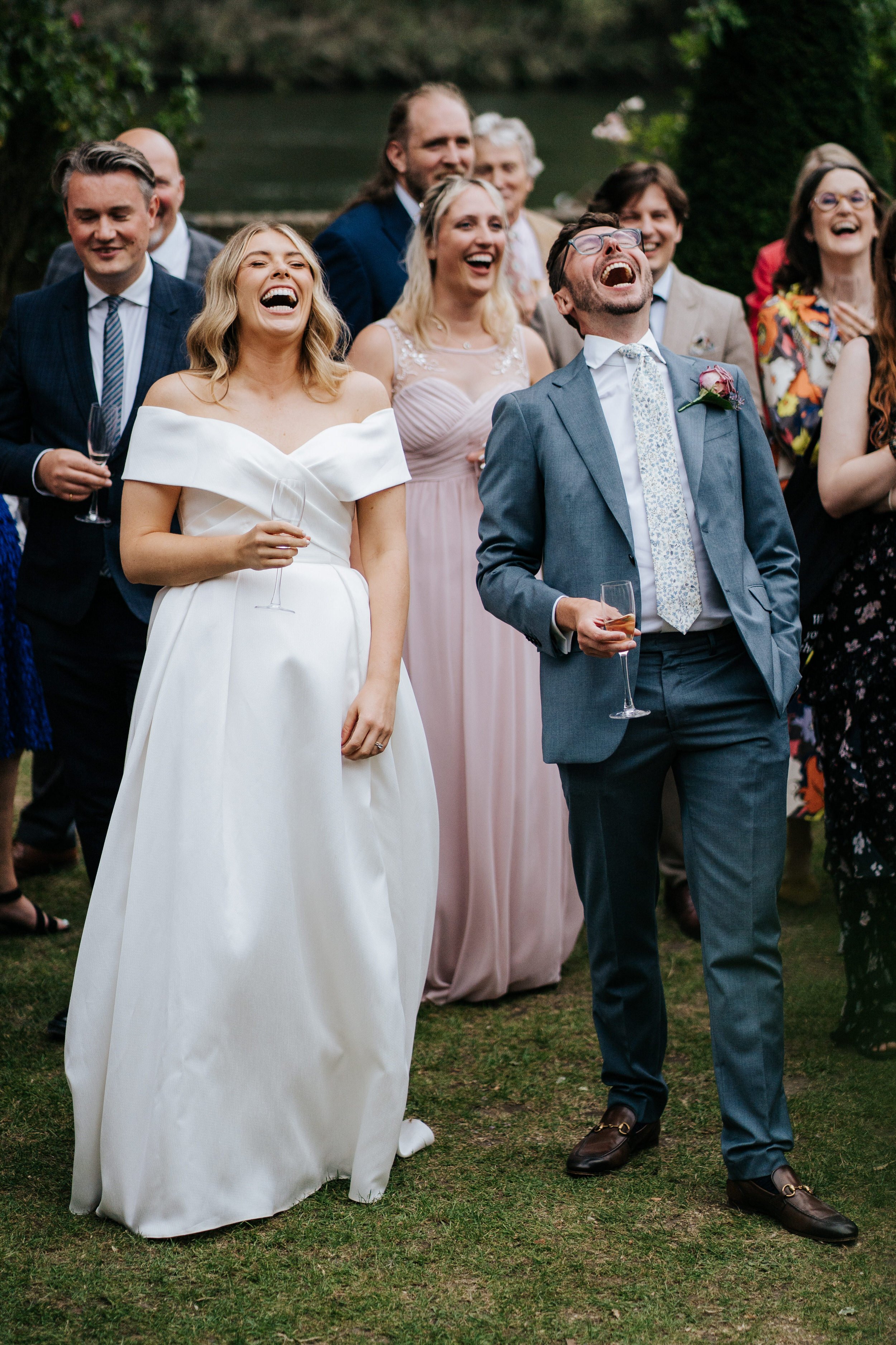 Bride and groom lean back and laugh during wedding speeches at Bingham Riverhouse wedding