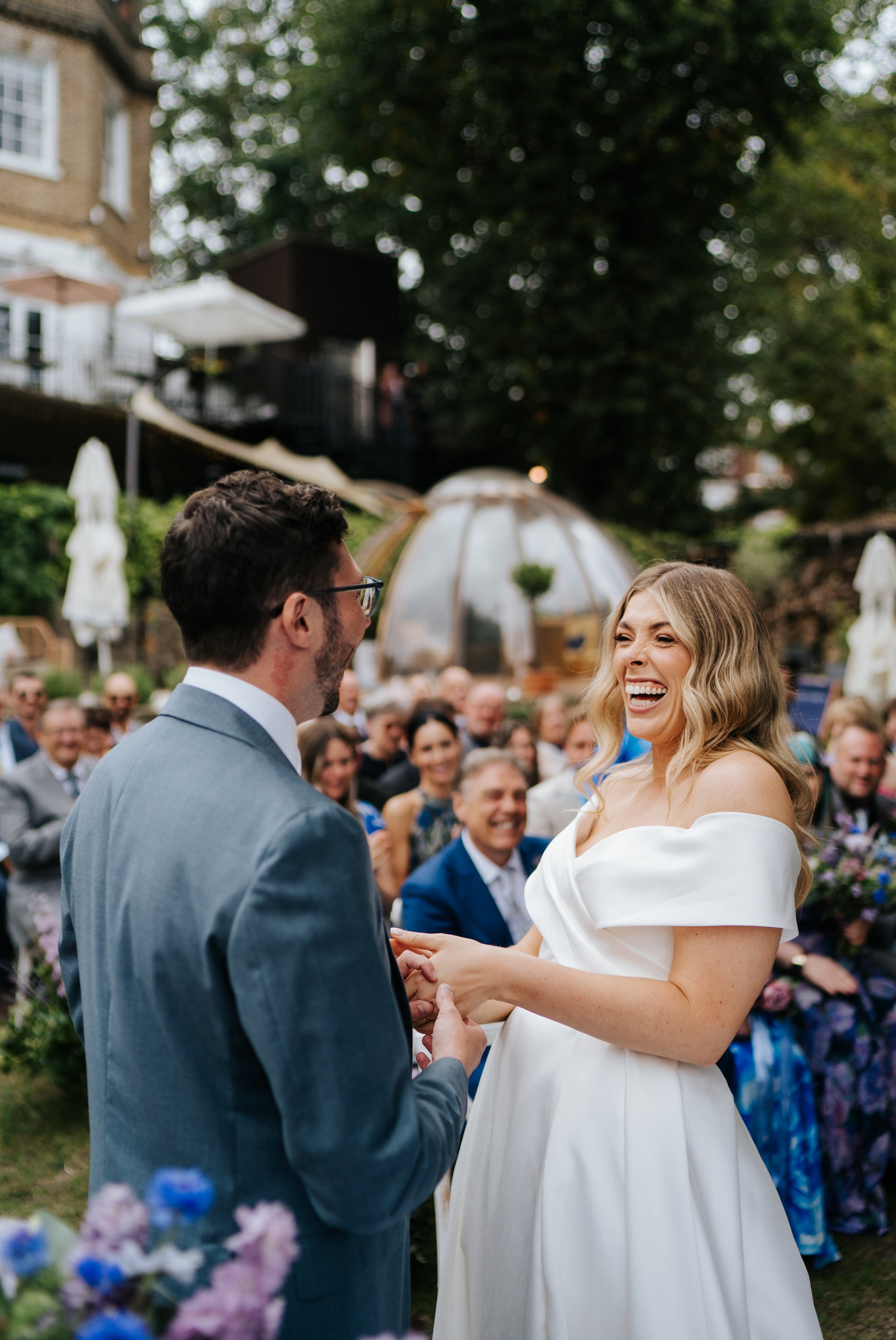 Bride cannot contain her excitement as she puts ring on groom's finger during Bingham Riverhouse wedding