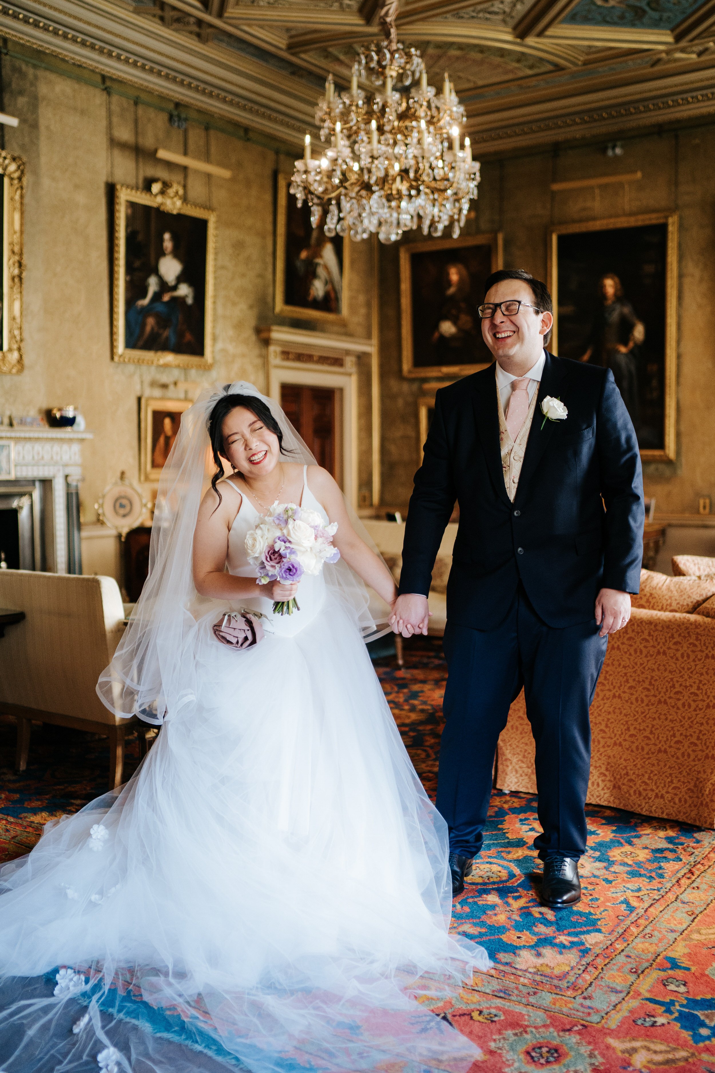 bride and groom pose in ornate room at Syon Park as they both laugh and smile