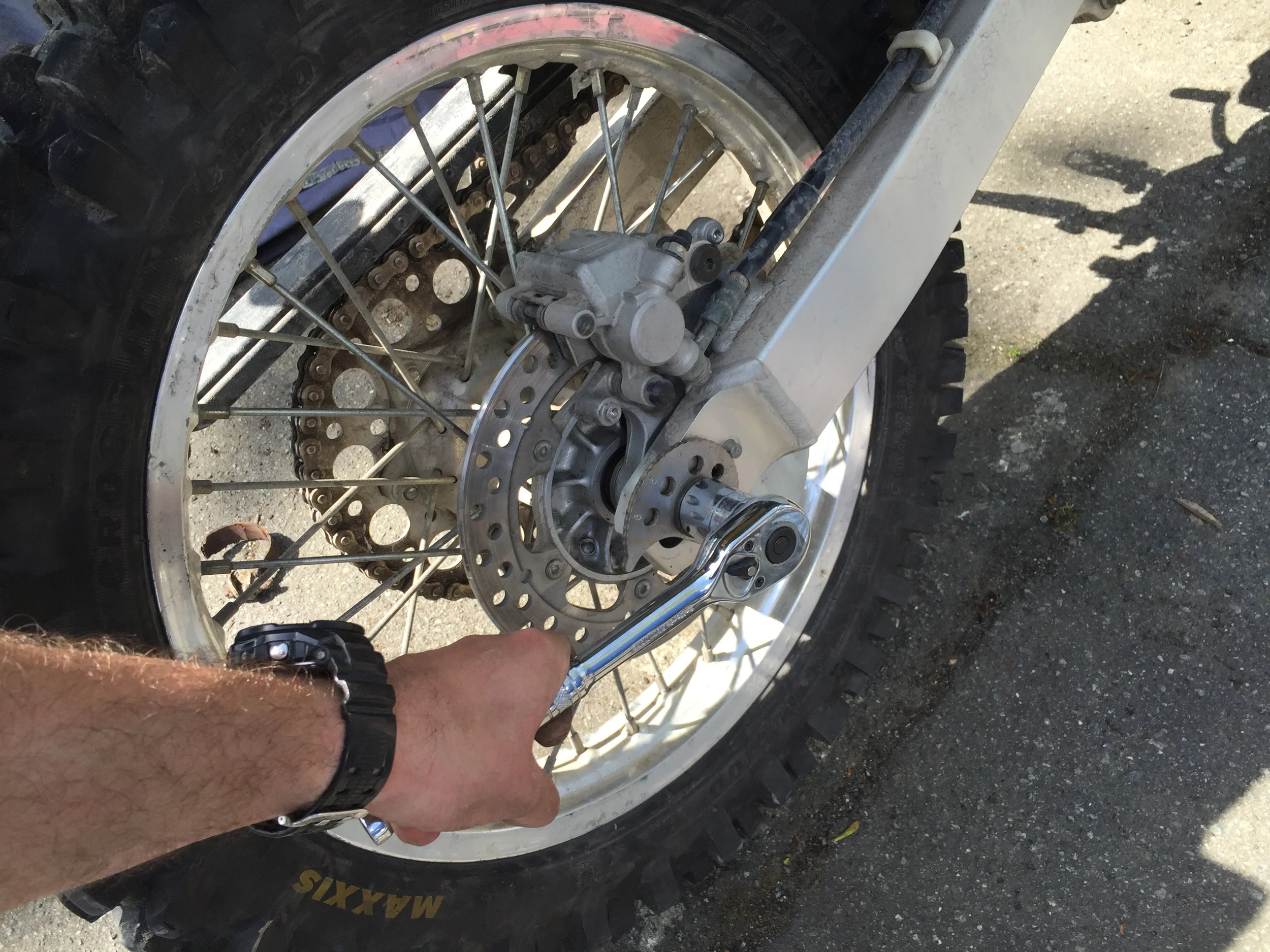 Crack off the nut with the wheel on the ground