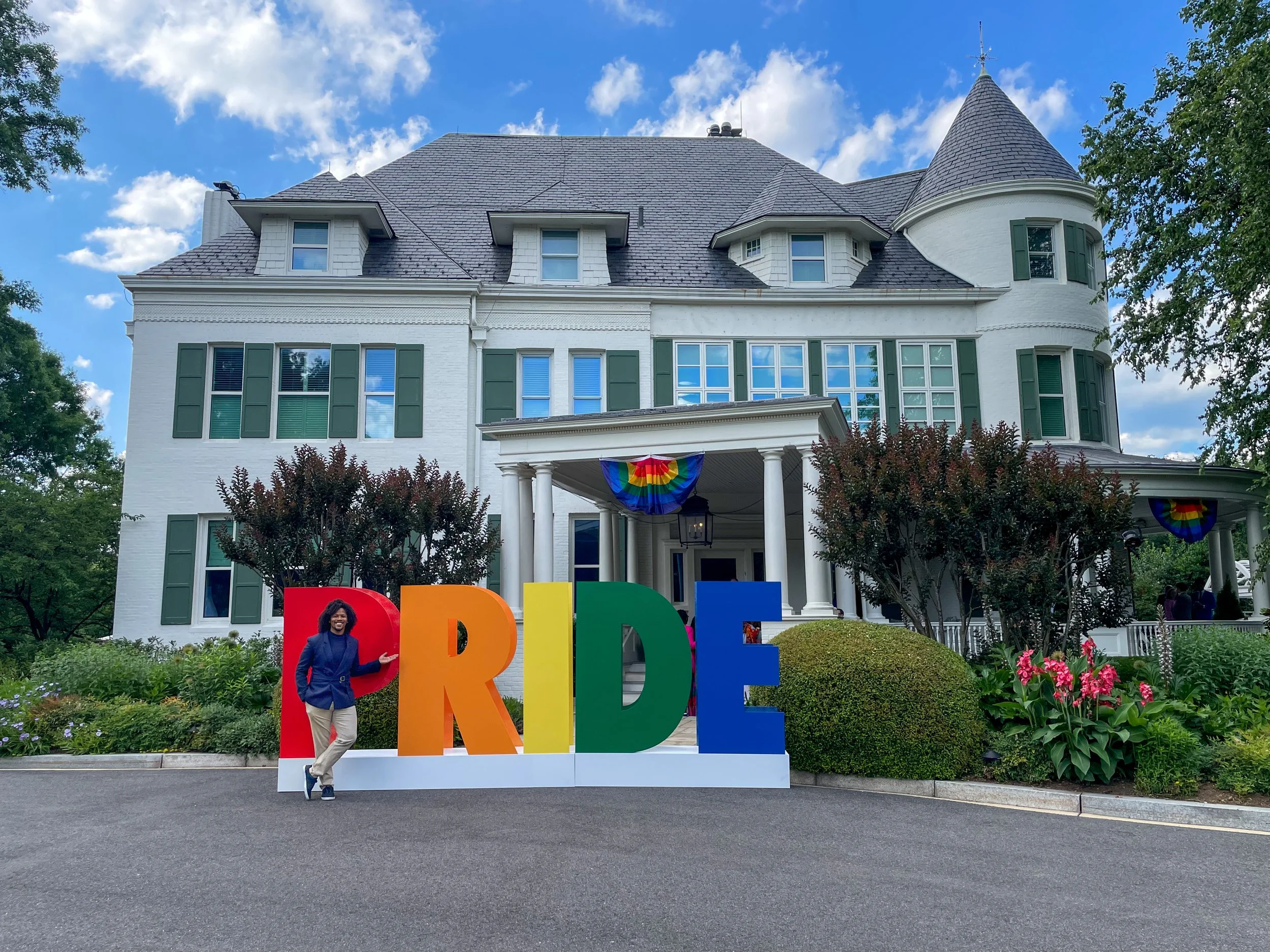  Matthew Jordan-Miller Kenyatta, Ph.D., standing in front of a large 'PRIDE' sign at the Vice President’s Residence in Washington, D.C., during the 2024 Pride Celebration. The event, hosted at the historic Naval Observatory, celebrates LGBTQ+ leaders