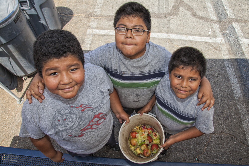  Young boys collect food for the worm compost bin after their class mates eat their lunch at the Downtown Value School, a charter school in downtown Los Angeles. 