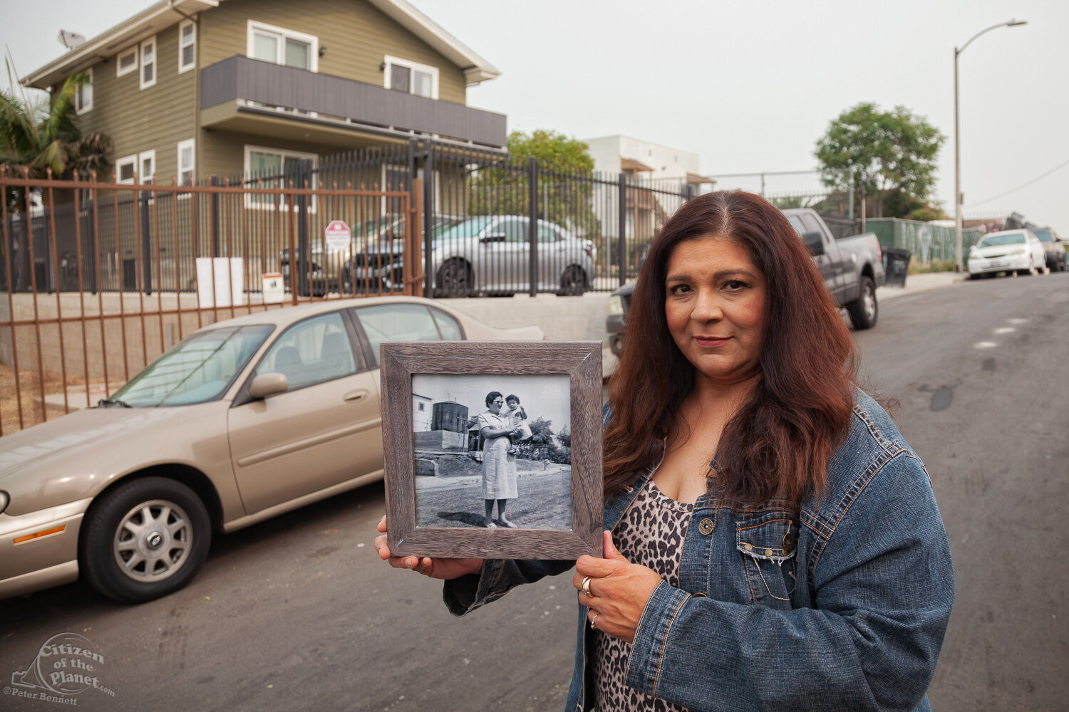  Lifelong resident and neighborhood activist, Rosalinda Morales stands on Firmin Street in the same location as a photo from 1958 of her aunt holding her in front of an oil tank. Dozens of abandoned wells still lie under homes and below ground along 