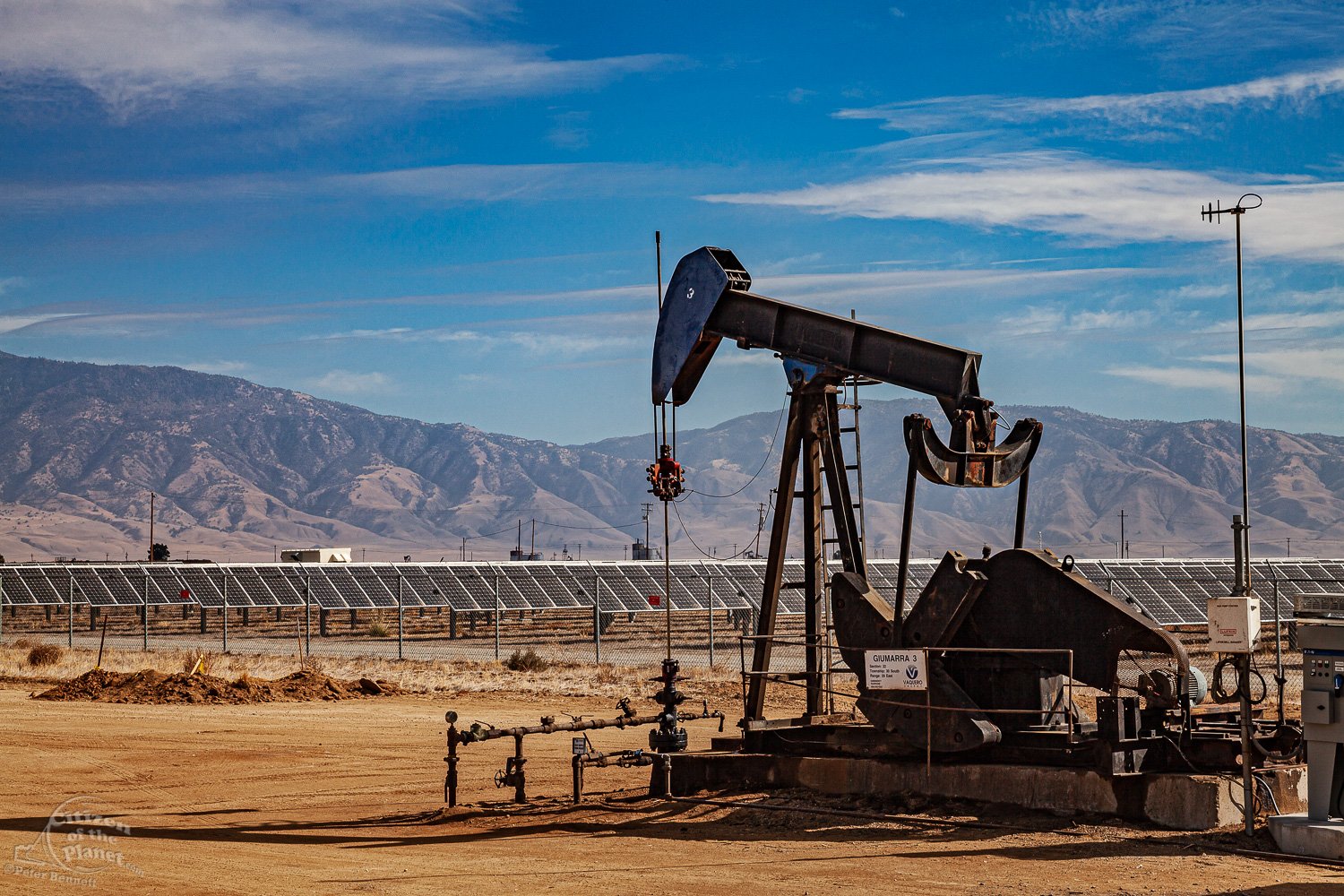  Lone pumpjack located in the middle of large solar array outside of Bakersfield, Kern Coutny 