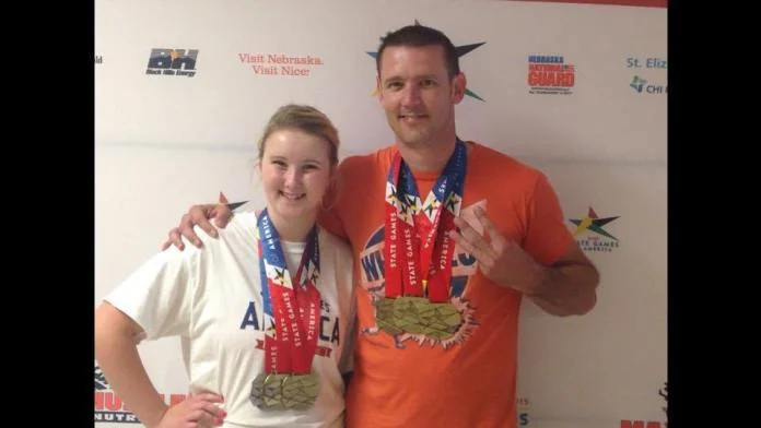 Quincey Epley (c/2019) and her father Matt (c/1995) celebrate success at a power lifting competition. Photo courtesy of Unattached Athlete.