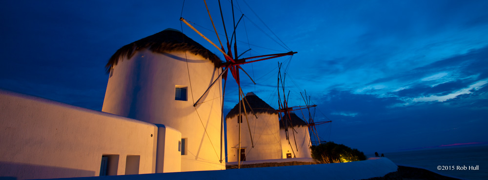 A wide angle lens captures the windmills and the twilight sky in Mykonos, Greece.