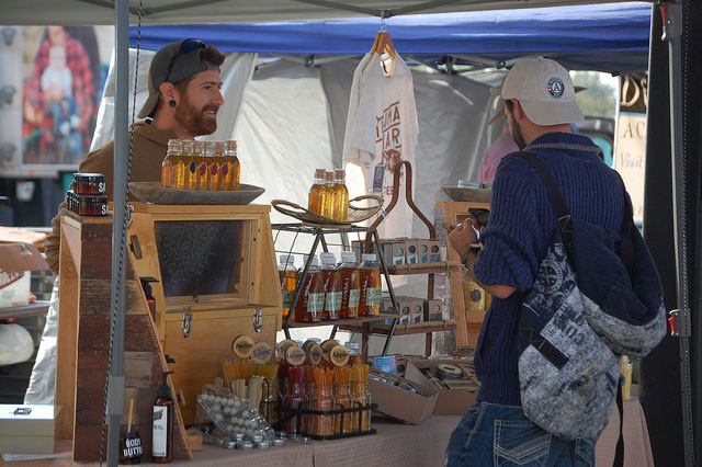 KJ Tencza of Illuman Apiary helping a customer at the Greeley Farmer's Market