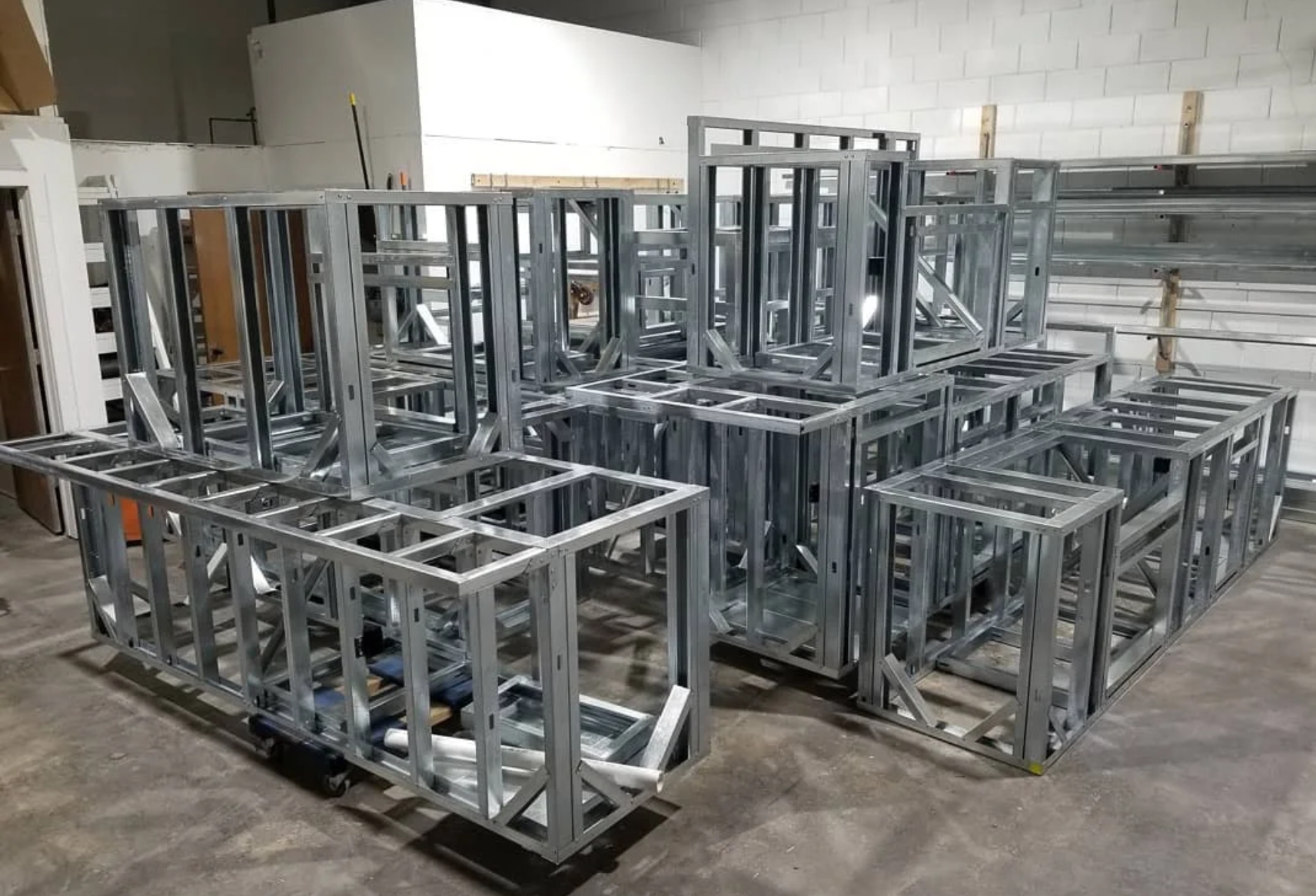 Stacked metal frames and structures in a warehouse or manufacturing area.