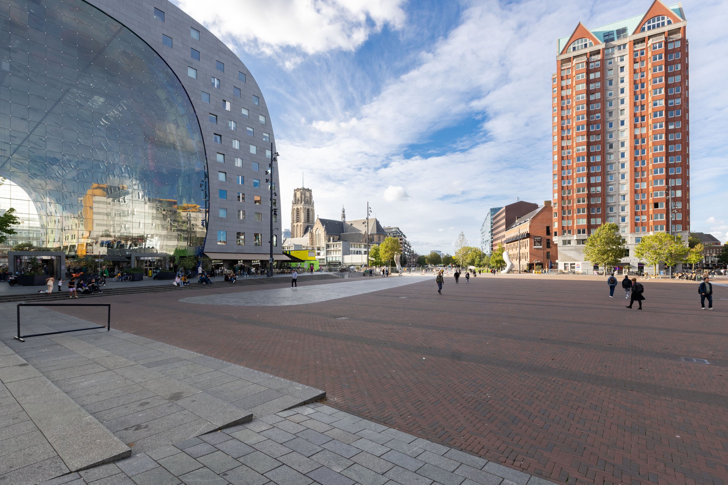 Markthal Rotterdam en toren op plein met mensen bij zonnig weer.