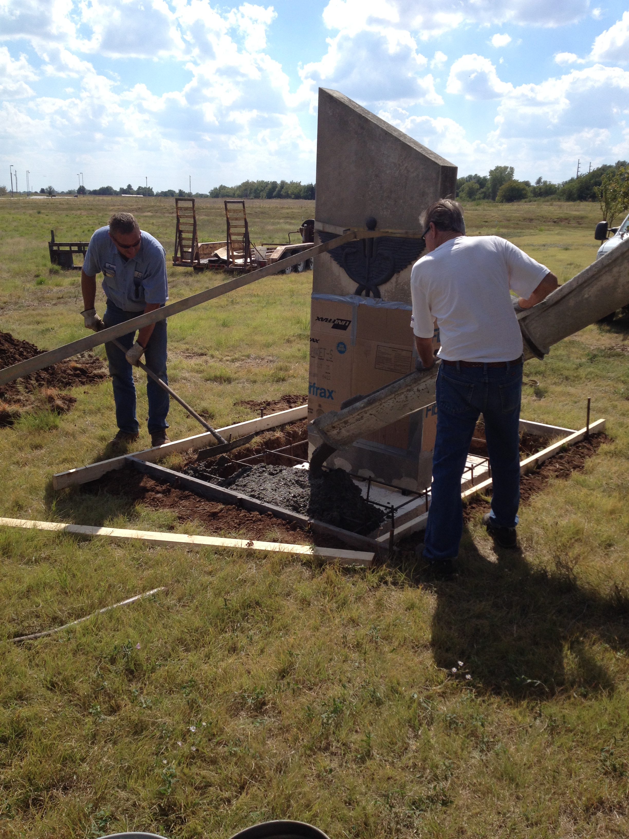 Pictured: Kevin Pike(left) and Rick Crull of LG Pike Construction complete the base for the caduceus stone which was recently relocated from the former site of Memorial Hospital to South Central Kansas Medical Center.