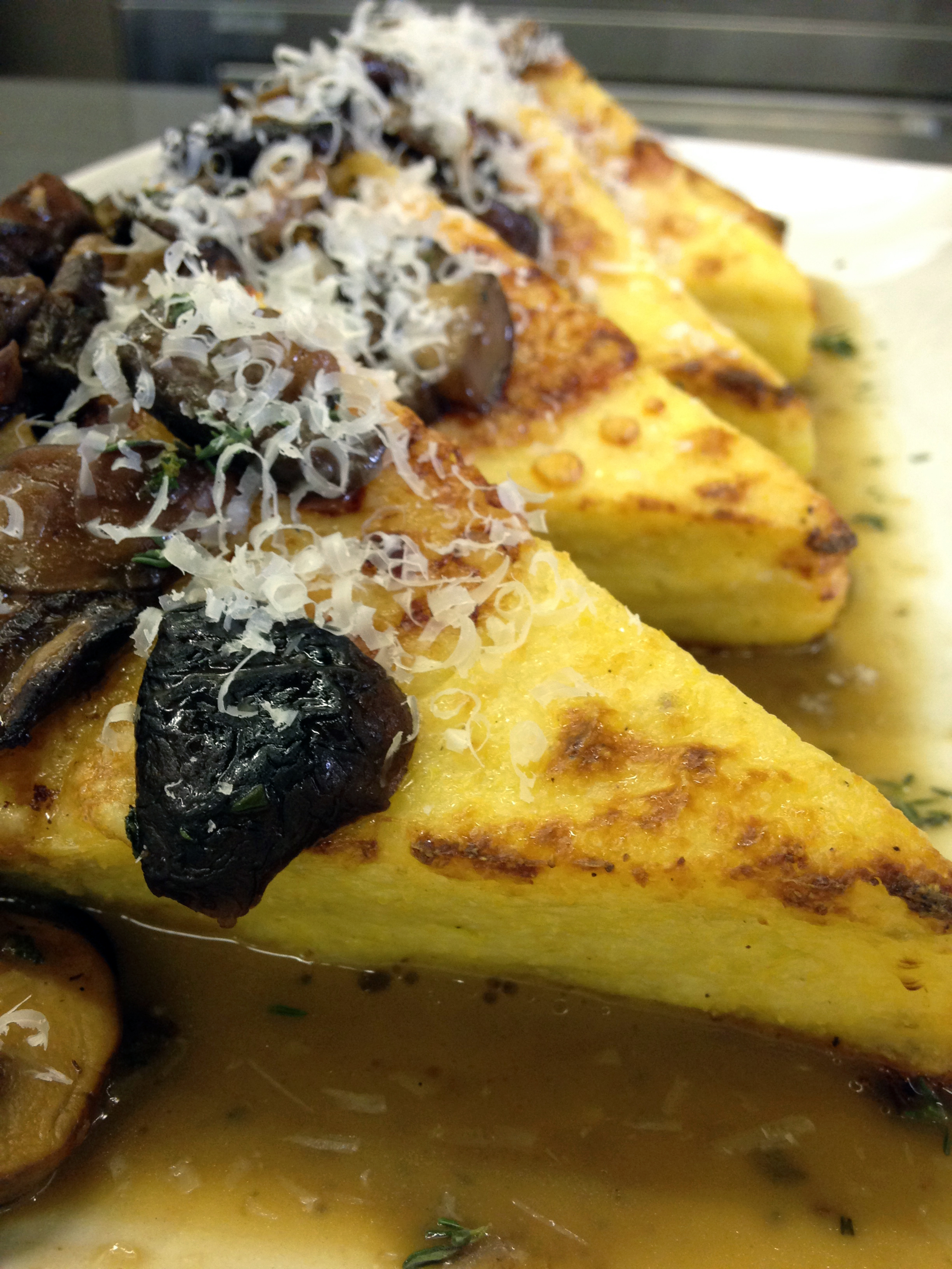 Chef Chris took our cooled polenta, cut it into triangles, topped with butter and Parmesan and baked it until golden. Then he added a savory mushroom sauce.