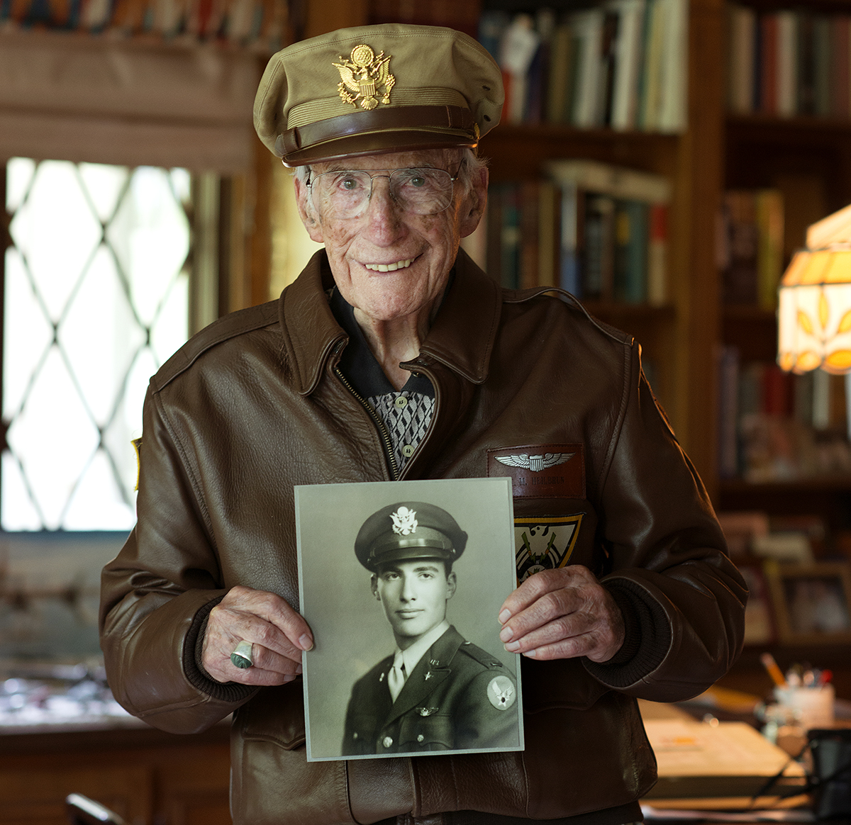 Herb in his bomber jacket and crusher cap holding his service portrait