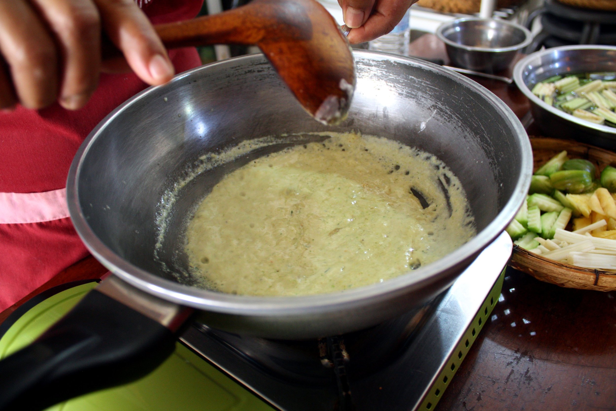  Frying curry paste in coconut milk to bring out the oil.&nbsp; 