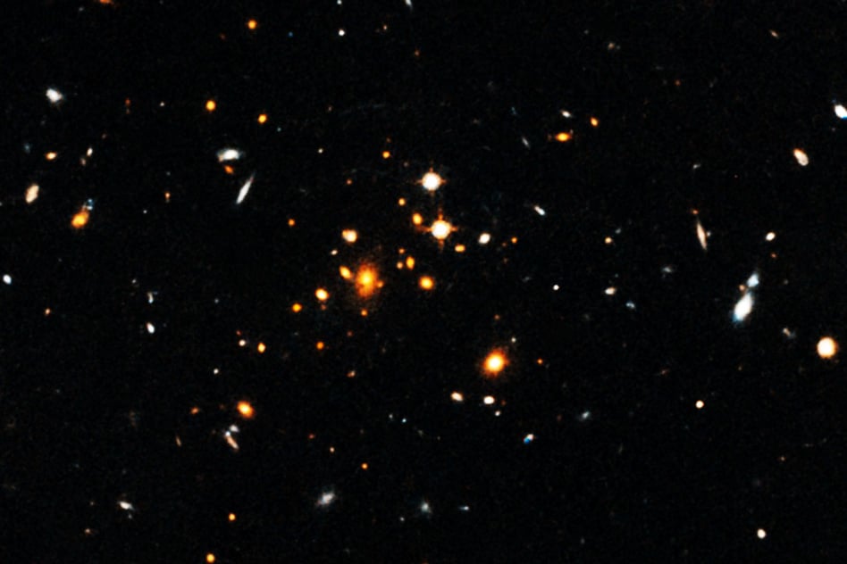 Astronomers have detected a massive, sprawling, churning galaxy cluster that formed only 3.8 billion years after the Big Bang. The cluster, shown here, is the most massive cluster of galaxies yet discovered in the first 4 billion years after the Big Bang. - Image Credit: NASA, European Space Agency, University of Florida, University of Missouri, and University of California