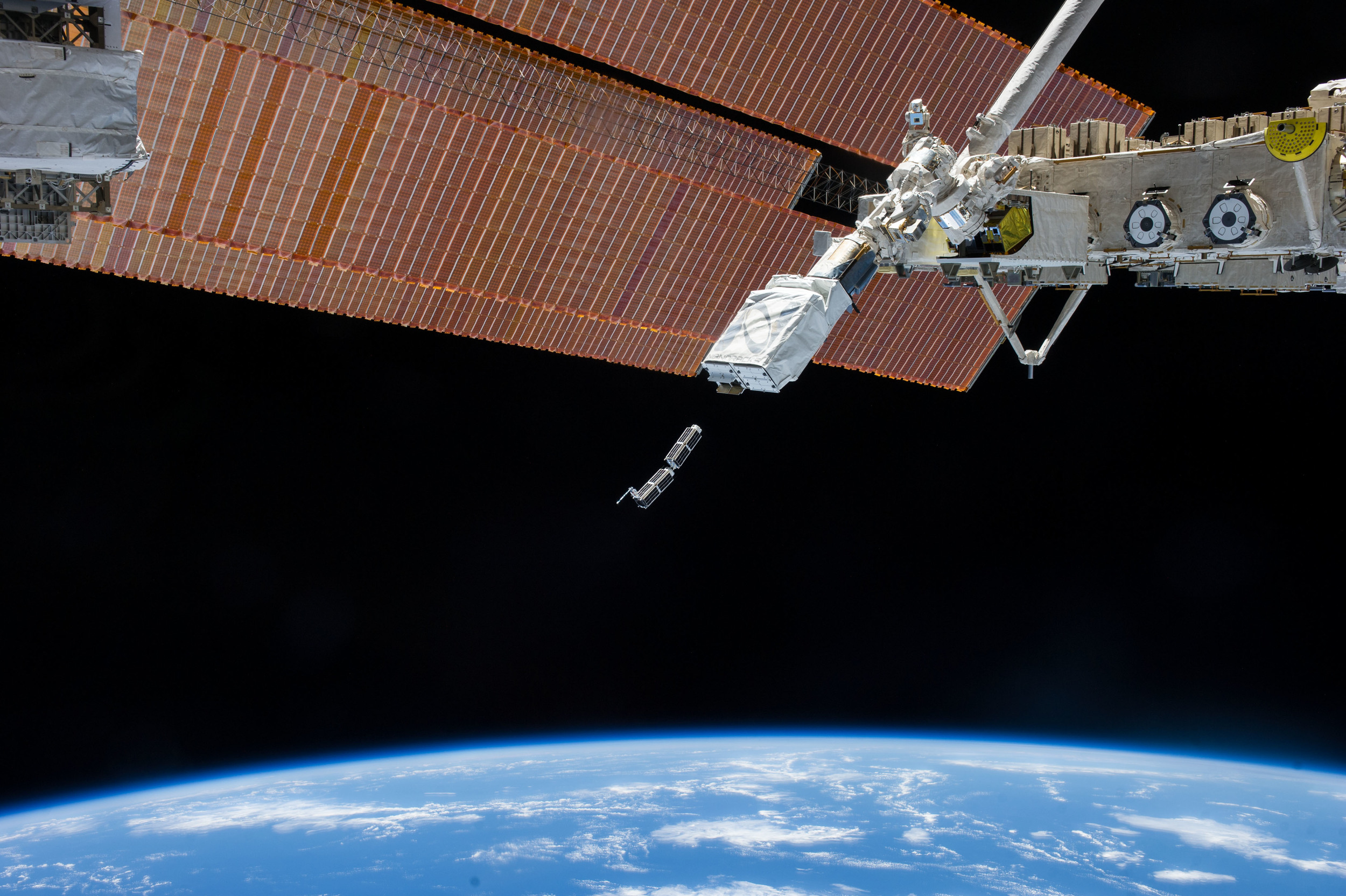 In February 2014, Planet Labs Inc. launched its first flock of Dove nanosatellites into space. Shown are two shoebox-sized Doves being ejected into low-Earth orbit from the International Space Station. The company’s goal is for the flock to take a high-resolution snapshot of nearly the entire globe every 24 hours. - Image Credits: NASA