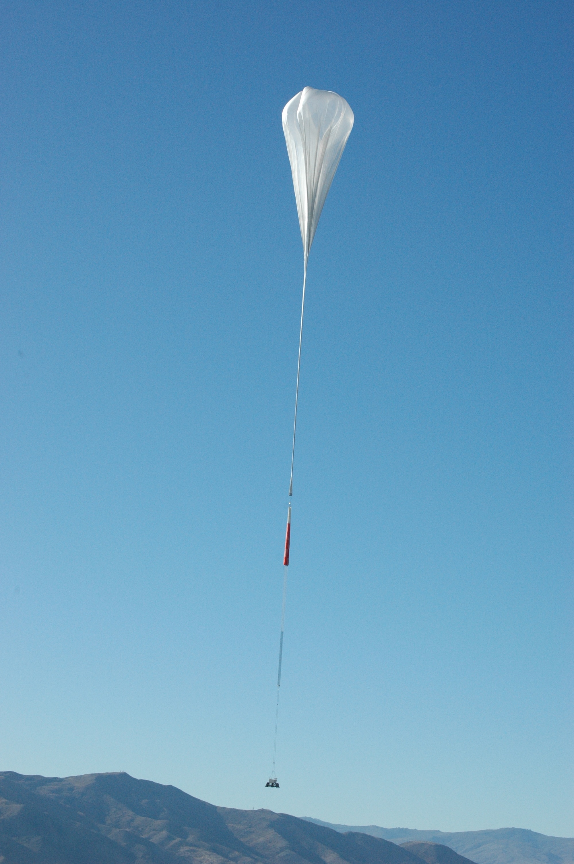 A NASA Super Pressure Balloon takes flight from Wanaka, New Zealand, in 2015. When fully inflated, the 18.8 million-cubic-foot (532,000 cubic meter) balloon is as large as a football stadium. During this year's New Zealand campaign, the balloon will carry the University of California, Berkeley's Compton Spectrometer and Imager (COSI) payload. - Image Credits: NASA