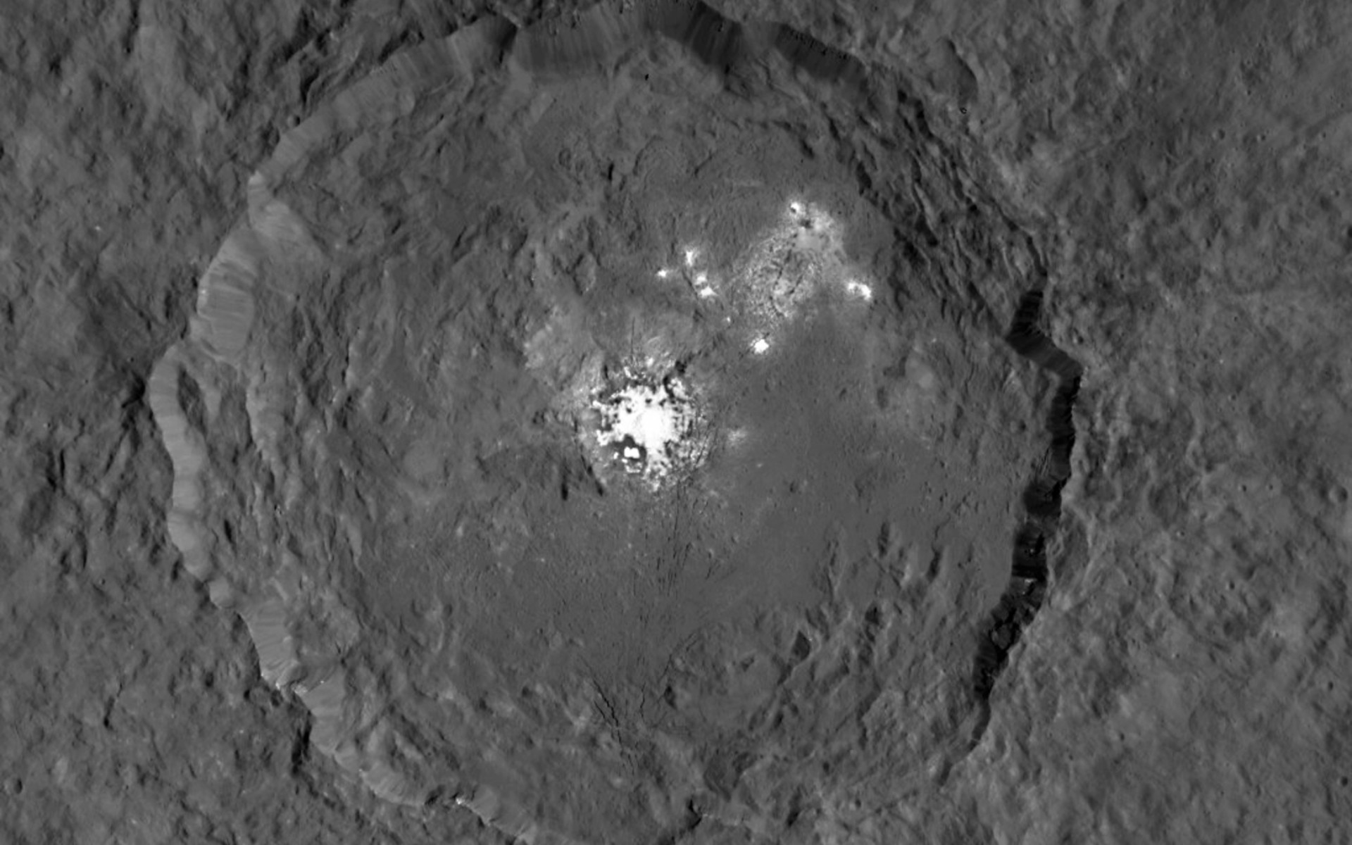 This image taken from NASA’s Dawn spacecraft in orbit around the dwarf planet Ceres shows the very bright patches of material in the crater Occator and elsewhere. New observations using the HARPS spectrograph on the ESO 3.6-metre telescope at La Silla in Chile have revealed unexpected daily changes on these spots, suggesting that they change under the influence of sunlight. - Image Credit: NASA/JPL-Caltech/UCLA/MPS/DLR/IDA