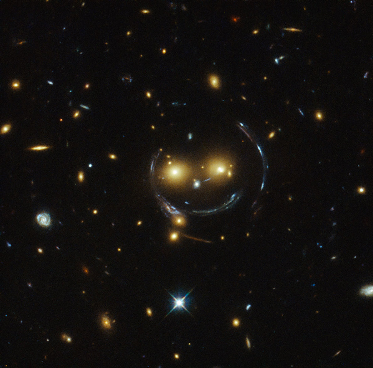 A spectacular smiling gravitational lens, observed by the Hubble Space Telescope. - Image Credit: NASA/ESA
