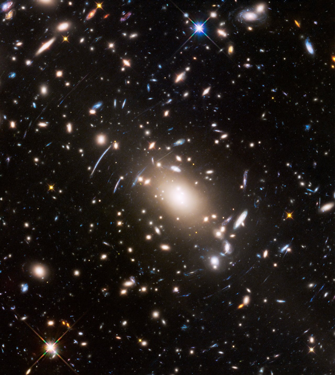 Abell S1063, a galaxy cluster, was observed by the NASA/ESA Hubble Space Telescope as part of the Frontier Fields programme. The huge mass of the cluster acts as a cosmic magnifying glass and enlarges even more distant galaxies, so they become bright enough for Hubble to see. – Image Credit: NASA, ESA, and J. Lotz (STScI)