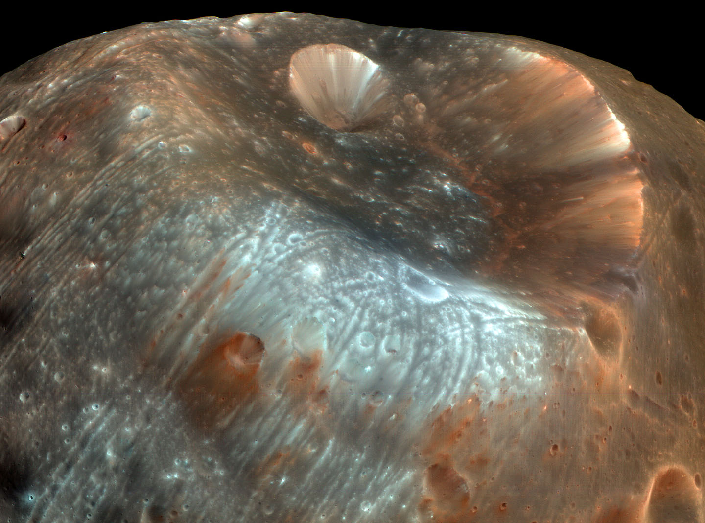 The streaked and stained surface of Phobos, with the Stickney crater shown in the center. - Image Credit: NASA/JPL/Mars Express