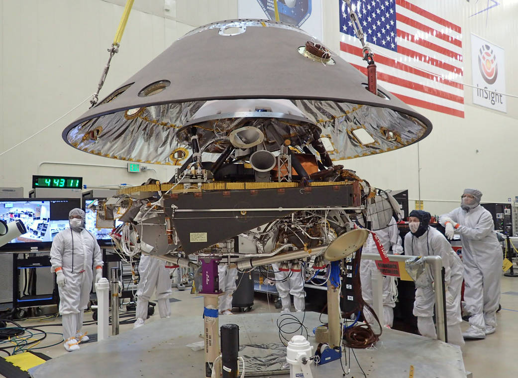 Back shell of NASA’s InSight spacecraft is being lowered onto the mission’s lander, which is folded into its stowed configuration. The back shell and a heat shield form the aeroshell, which will protect the lander as the spacecraft plunges into the upper atmosphere of Mars. Launch now rescheduled to May 2018 to fix French-built seismometer. - Image Credit: NASA/JPL-Caltech/Lockheed Martin
