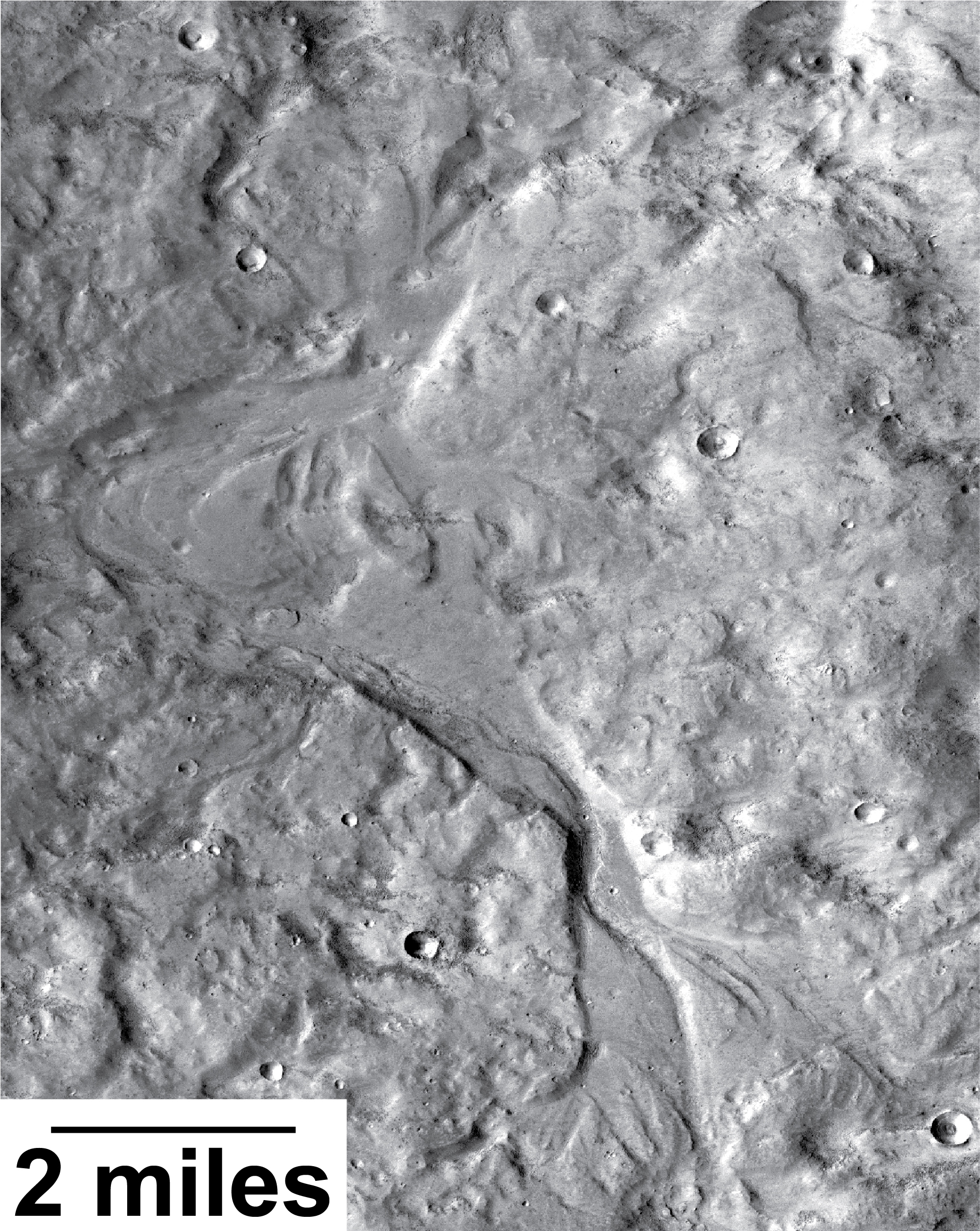 Streamlined forms in this Martian valley resulted from the outflow of a lake hundreds of millions years more recently than an era of Martian lakes previously confirmed. This image from the Context Camera on NASA's Mars Reconnaissance Orbiter covers an area in Arabia Terra about 8 miles wide. - Image Credits: NASA/JPL-Caltech/MSSS