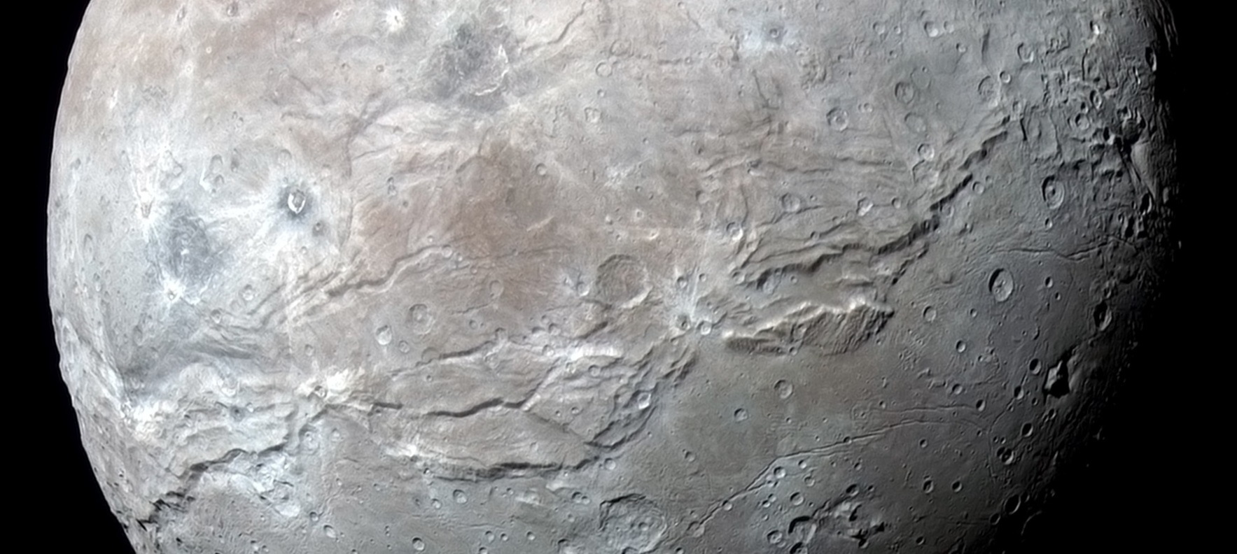 Charon’s vast equatorial chasms. The most obvious ones are unofficially named Macross Chasma (on the left) and Serenity Chasma (on the right). – Image Credit: NASA/Johns Hopkins University Applied Physics Laboratory/Southwest Research Institute