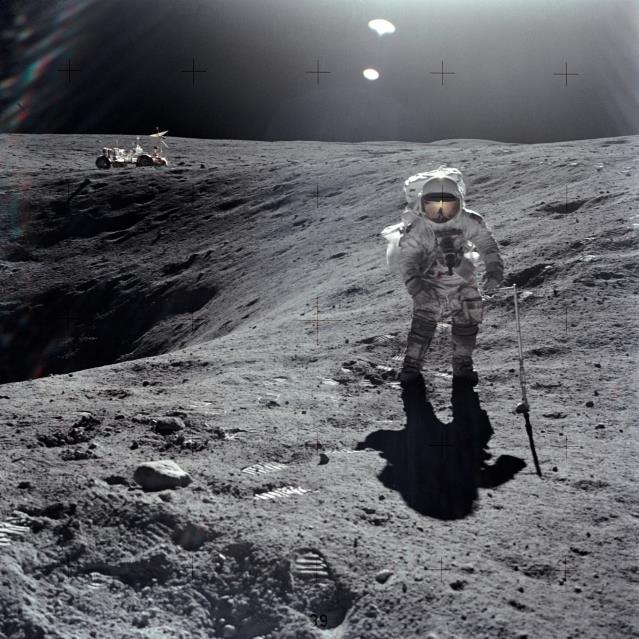 Sample collection on the surface of the Moon. Apollo 16 astronaut Charles M. Duke Jr. is shown collecting samples with the Lunar Roving Vehicle in the left background - Image Credit: NASA