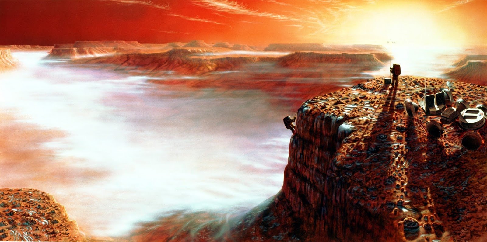 The area depicted is Noctis Labyrinthus in the Valles Marineris system of enormous canyons. The scene is just after sunrise, and on the canyon floor four miles below, early morning clouds can be seen. The frost on the surface will melt very quickly as the Sun climbs higher in the Martian sky. - Image Credit: NASA