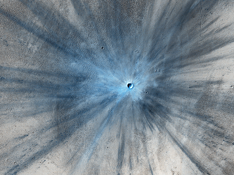 A new impact crater that was formed between July 2010 and May 2012, as seen by the HiRISE camera on the Mars Reconnaissance Orbiter. This image is part of “A Fictive Flight Above Real Mars” by Jan Fröjdman. - Image Credit: NASA/JPL/University of Arizona.