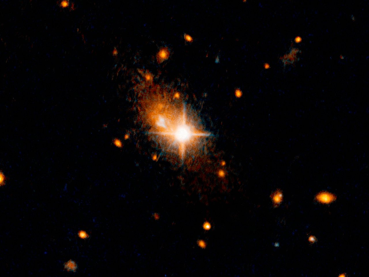 The bright, star-like looking quasar can be seen in the centre of the image. Its former host galaxy is the faint, extended object behind it. - Image Credit: NASA, ESA, and M. Chiaberge (STScI/ESA)