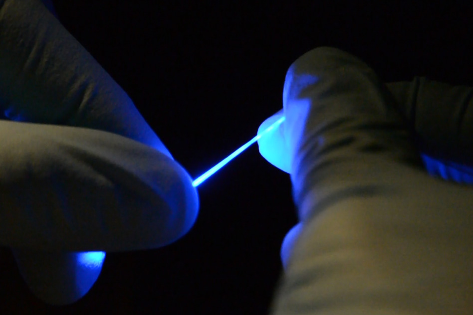 Researchers have developed a rubber-like fiber, shown here, that can flex and stretch while simultaneously delivering both optical impulses, for optoelectronic stimulation, and electrical connections, for stimulation and monitoring. - Image Credit: Chi (Alice) Lu and Seongjun Park