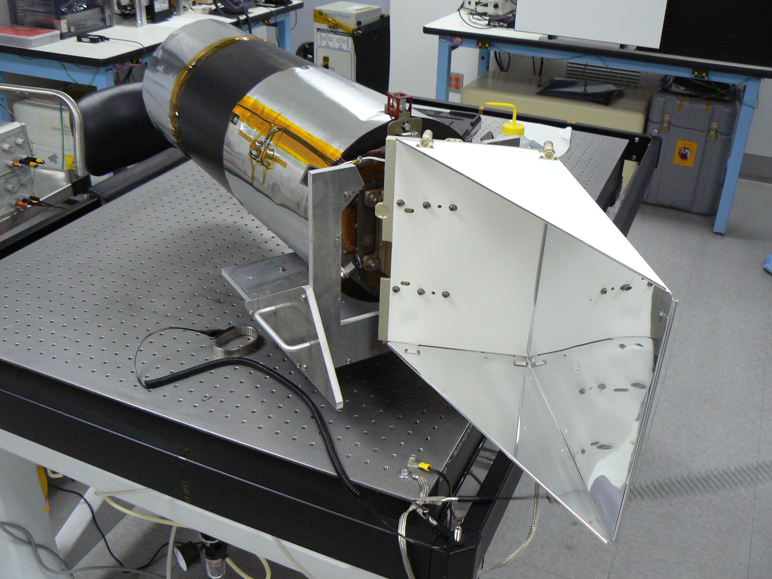 The Narrow Angle Camera sits on a bench in the clean room at Malin Space Science Systems. The radiator (right) extends off the electronics end and keeps the sensor cool while imaging the moon. Computer modeling shows the meteoroid impacted somewhere on the radiator.. - Image Credits: Malin Space Science Systems/Arizona State University