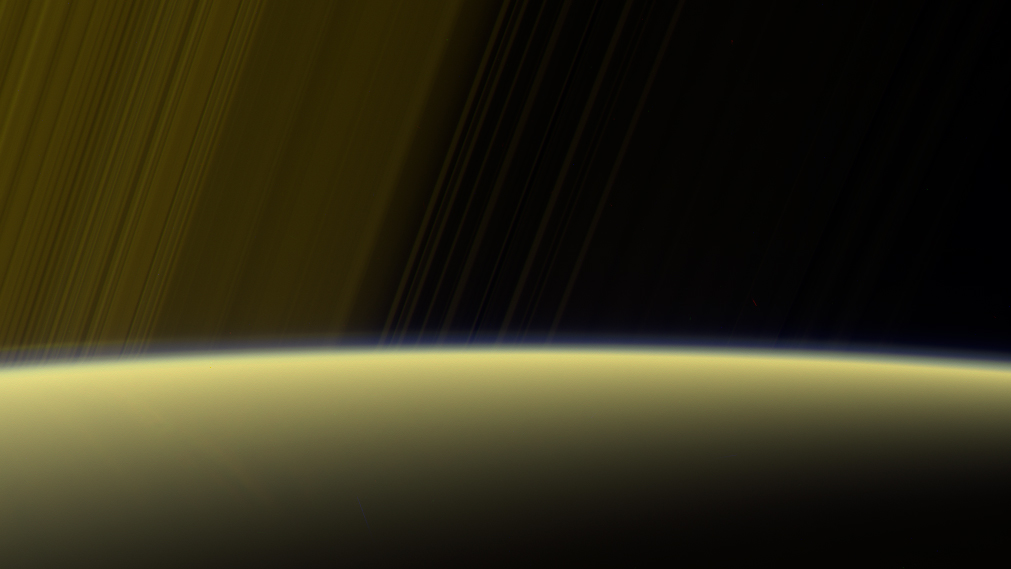 This false-color view from NASA's Cassini spacecraft gazes toward the rings beyond Saturn's sunlit horizon, where a thin haze can be seen along the limb. - Image Credits: NASA/JPL-Caltech/Space Science Institute