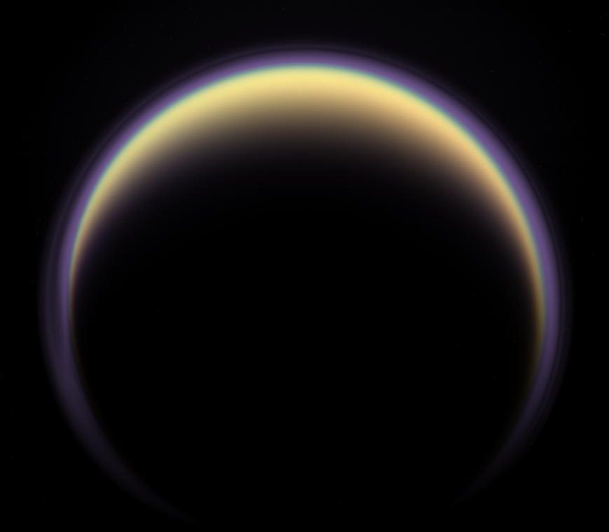 A halo of light surrounds Saturn’s moon Titan in this backlit picture, showing its atmosphere. - Image Credit: NASA/JPL/Space Science Institute