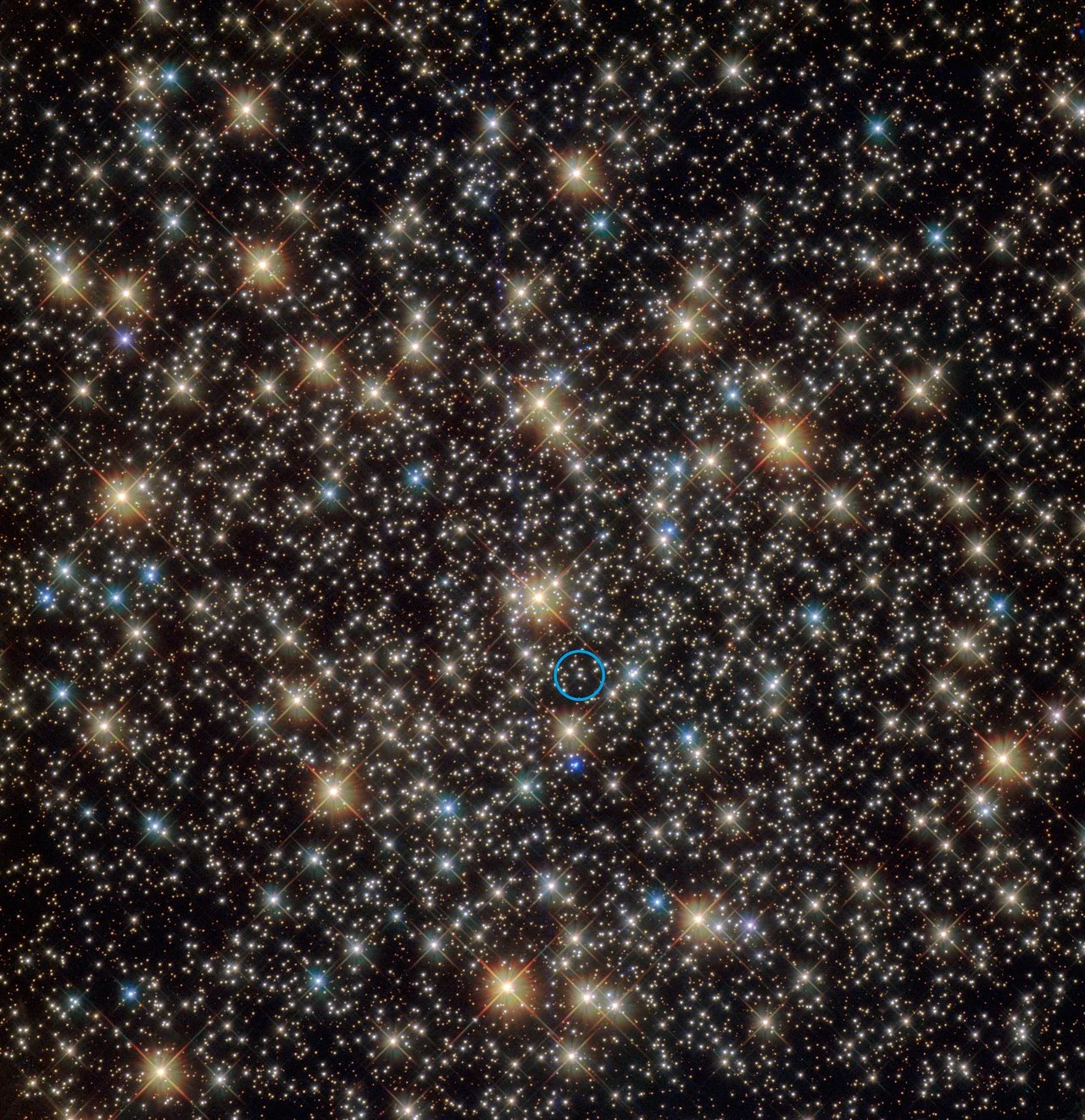 This image from the NASA/ESA Hubble Space Telescope shows the central region of the rich globular star cluster NGC 3201 in the southern constellation of Vela (The Sails). A star that has been found to be orbiting a black hole with four times the mass of the Sun is indicated with blue circle. - Image Credit: ESA/NASA