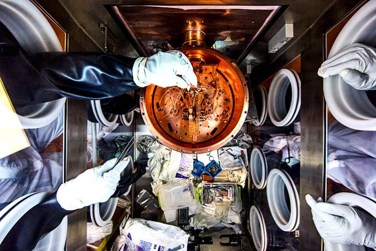 Researchers work on the delicate wiring of a cryostat, which chills the detectors that are the heart of the MAJORANA DEMONSTRATOR. - Image Credit: Matthew Kapust/Sanford Underground Research Facility via U. Washington