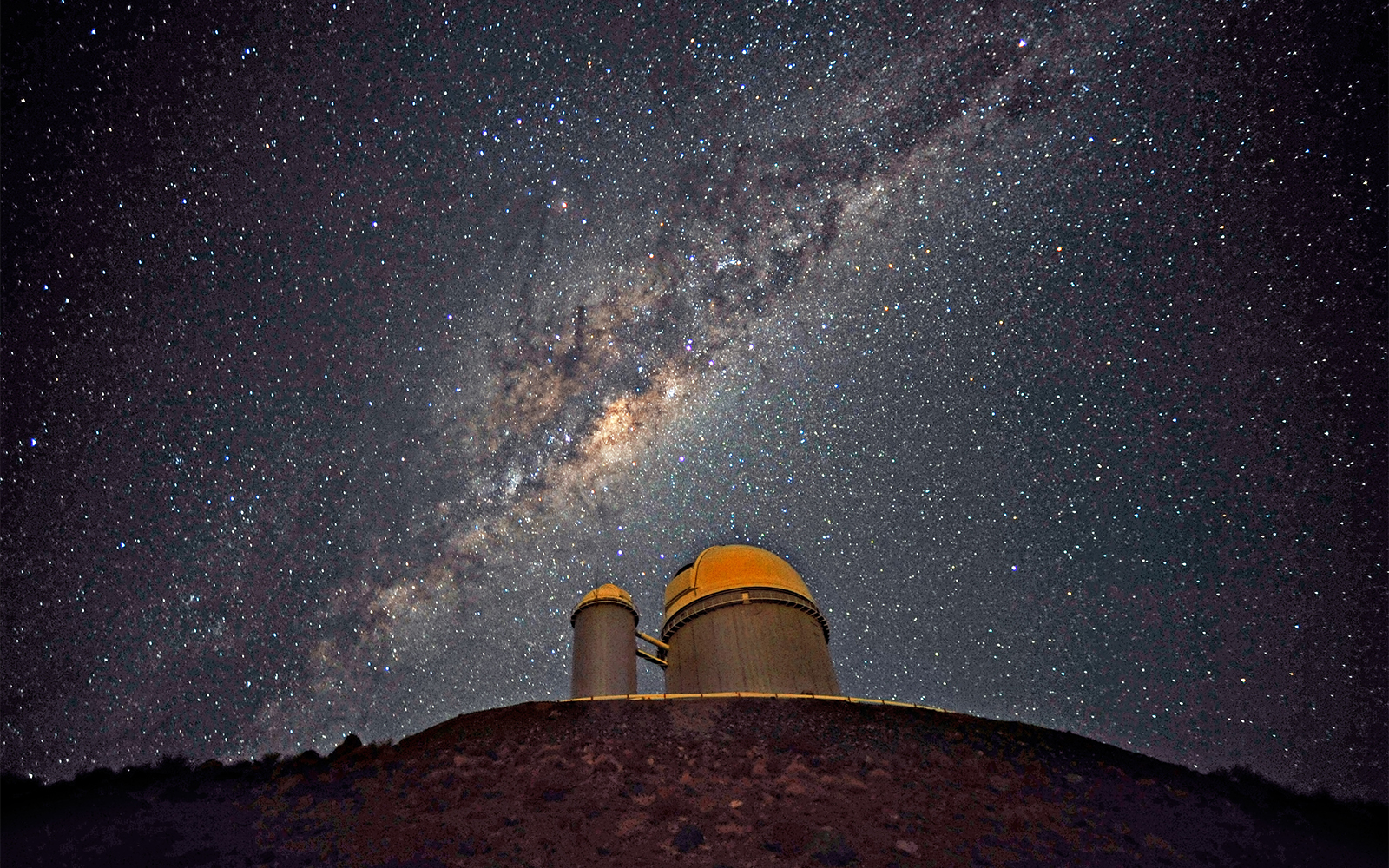 The Milky Way, our own galaxy, stretches across the sky above the La Silla telescope in Chile. Hidden inside our own galaxy are trillions of planets, most waiting to be found. - Image Credits: ESO/S. Brunier