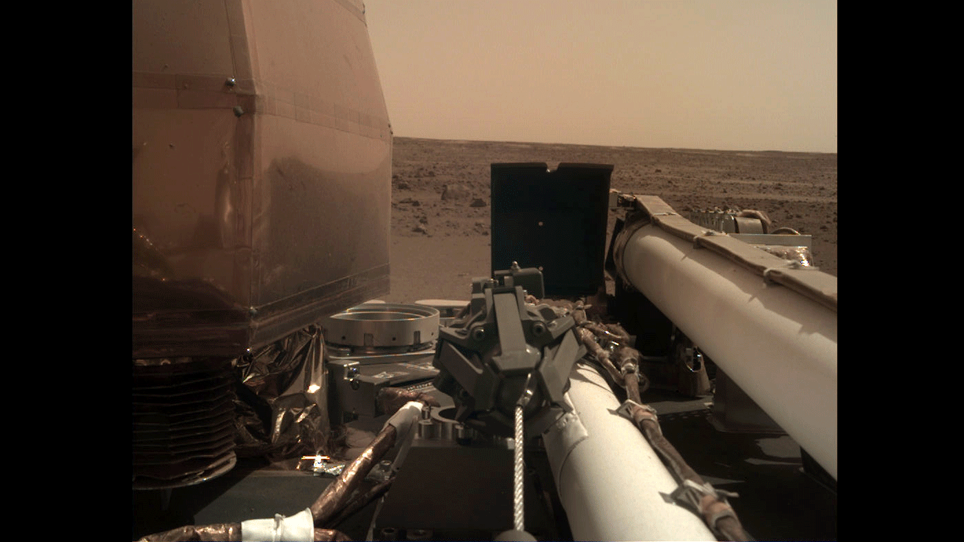 As visible in this two-frame set of images, NASA’s InSight spacecraft unlatched its robotic arm on Nov. 27, 2018, the day after it landed on Mars. - Image Credit: NASA/JPL-Caltech