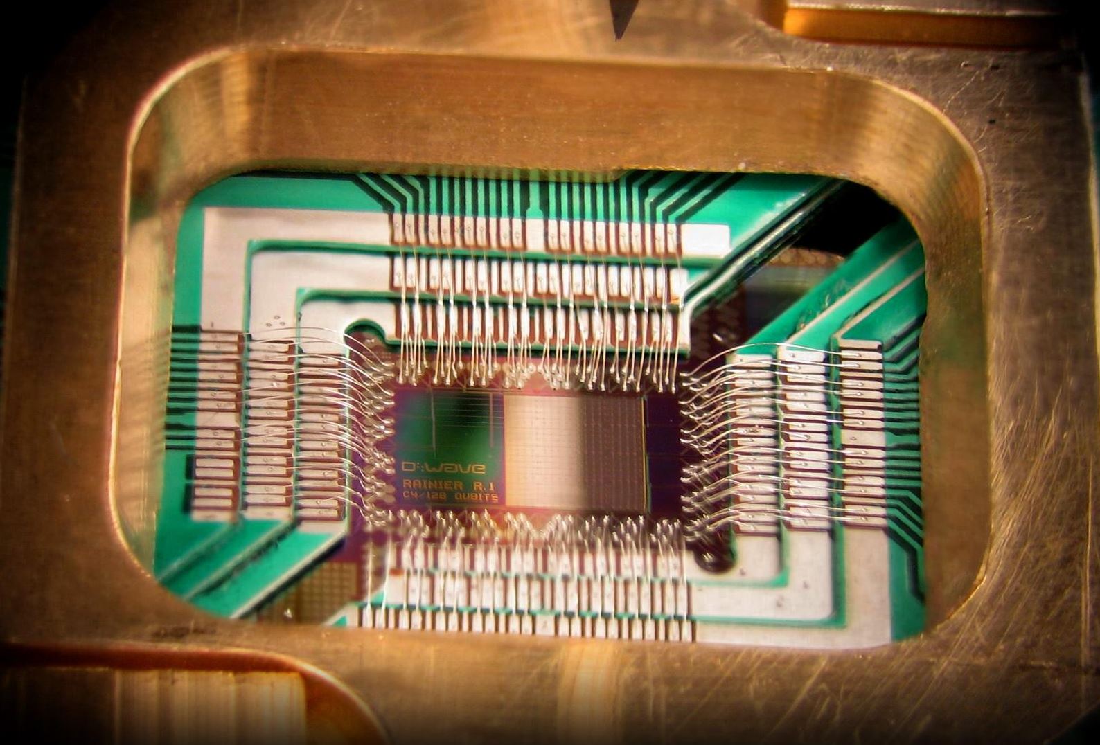 Photograph of a chip constructed by D-Wave Systems Inc. designed to operate as a 128-qubit superconducting adiabatic quantum optimization processor, mounted in a sample holder. Image Credit: D-Wave Systems, Inc. via Wikimedia Commons