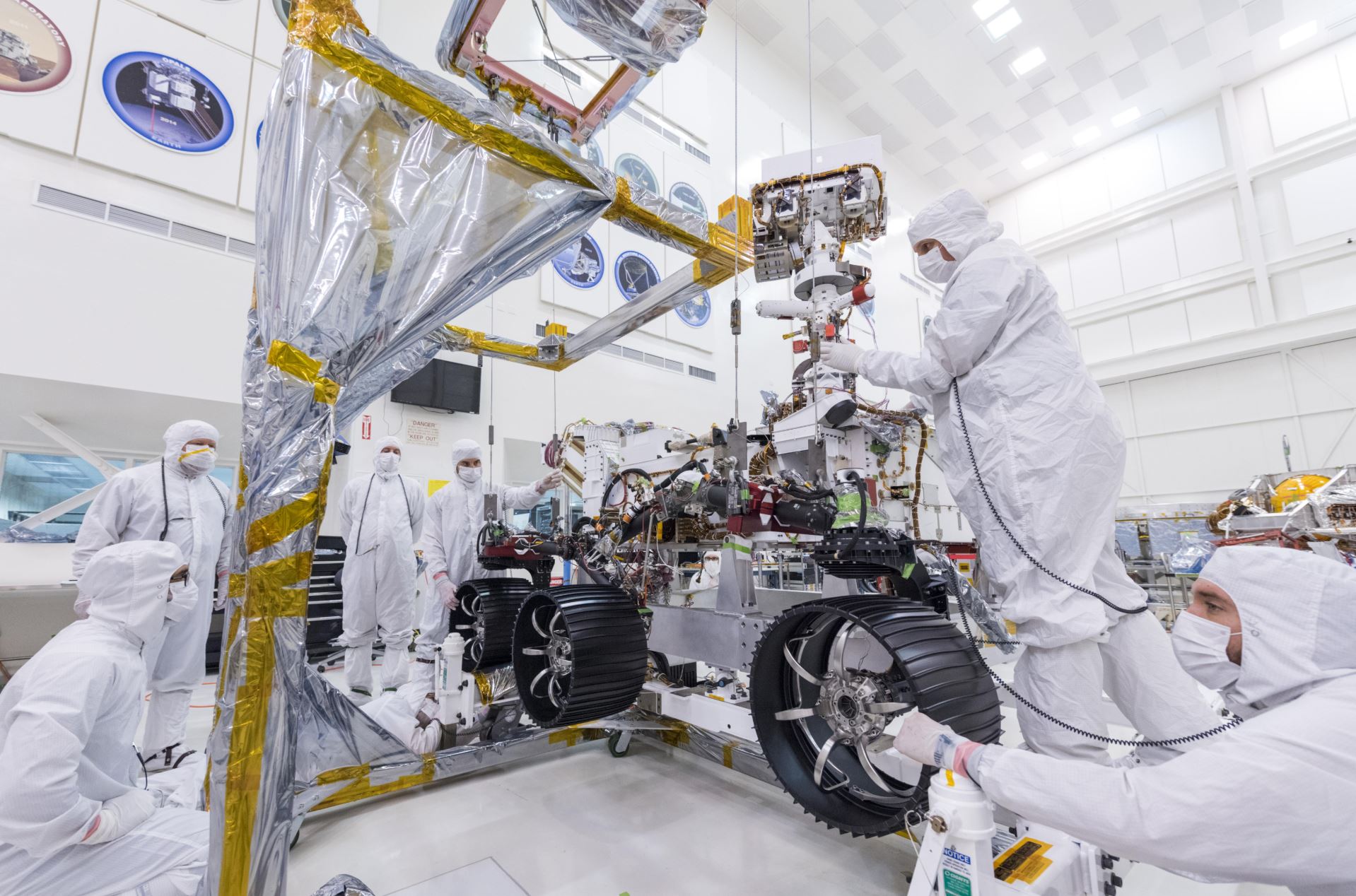 In this image, taken on June 13, 2019, engineers at JPL install the starboard legs and wheels - otherwise known as the mobility suspension - on the Mars 2020 rover. Credit: NASA/JPL-Caltech - Image credit: NASA/JPL-Caltech