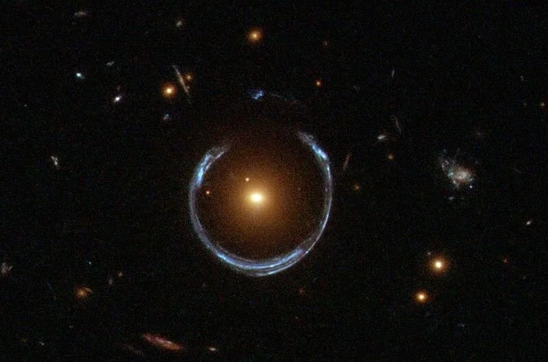 A gravitational lens mirage - Its multiple properties allow astronomers to determine the mass and dark matter content of the foreground galaxy lenses. - Image Credit: ESA/Hubble & NASA via Wikimedia Commons