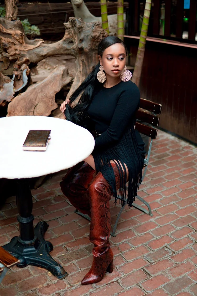I am wearing a ribbed fringe sleeve mini dress by Akira , PLT studded belt and snakeskin thigh high boots , double disc earrings from Forever 21 , vintage clutch, bangles and ring I got forever ago.